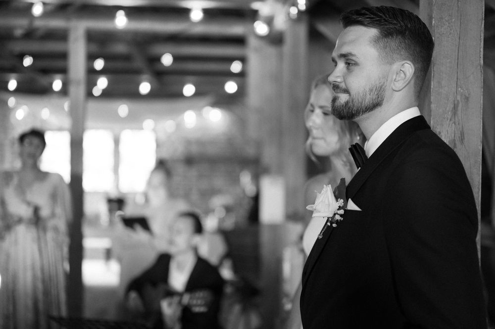 Formal wedding celebration in an industrial-style venue with overhead lighting.