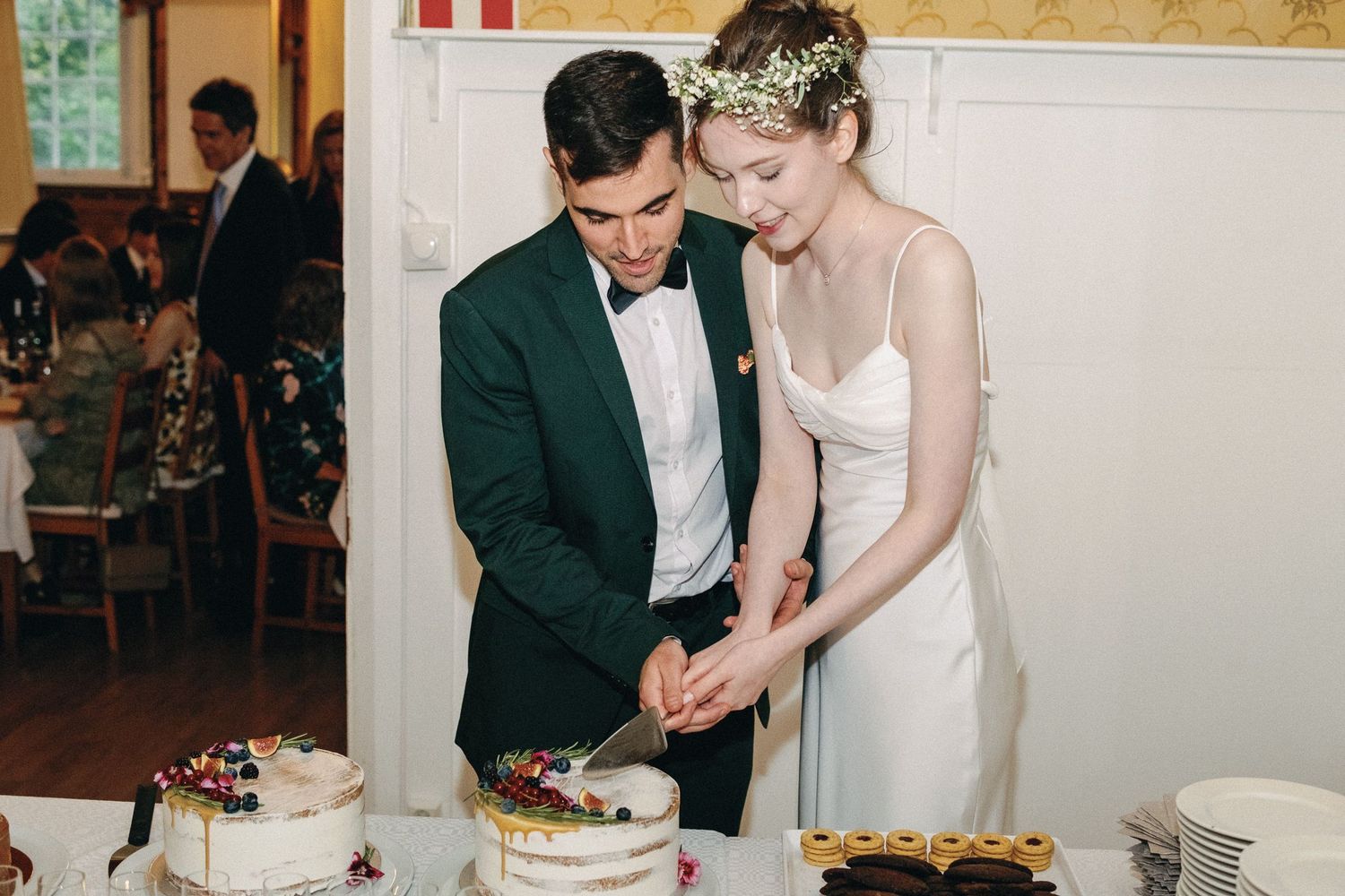 Newlyweds cutting their wedding cake together at the reception.