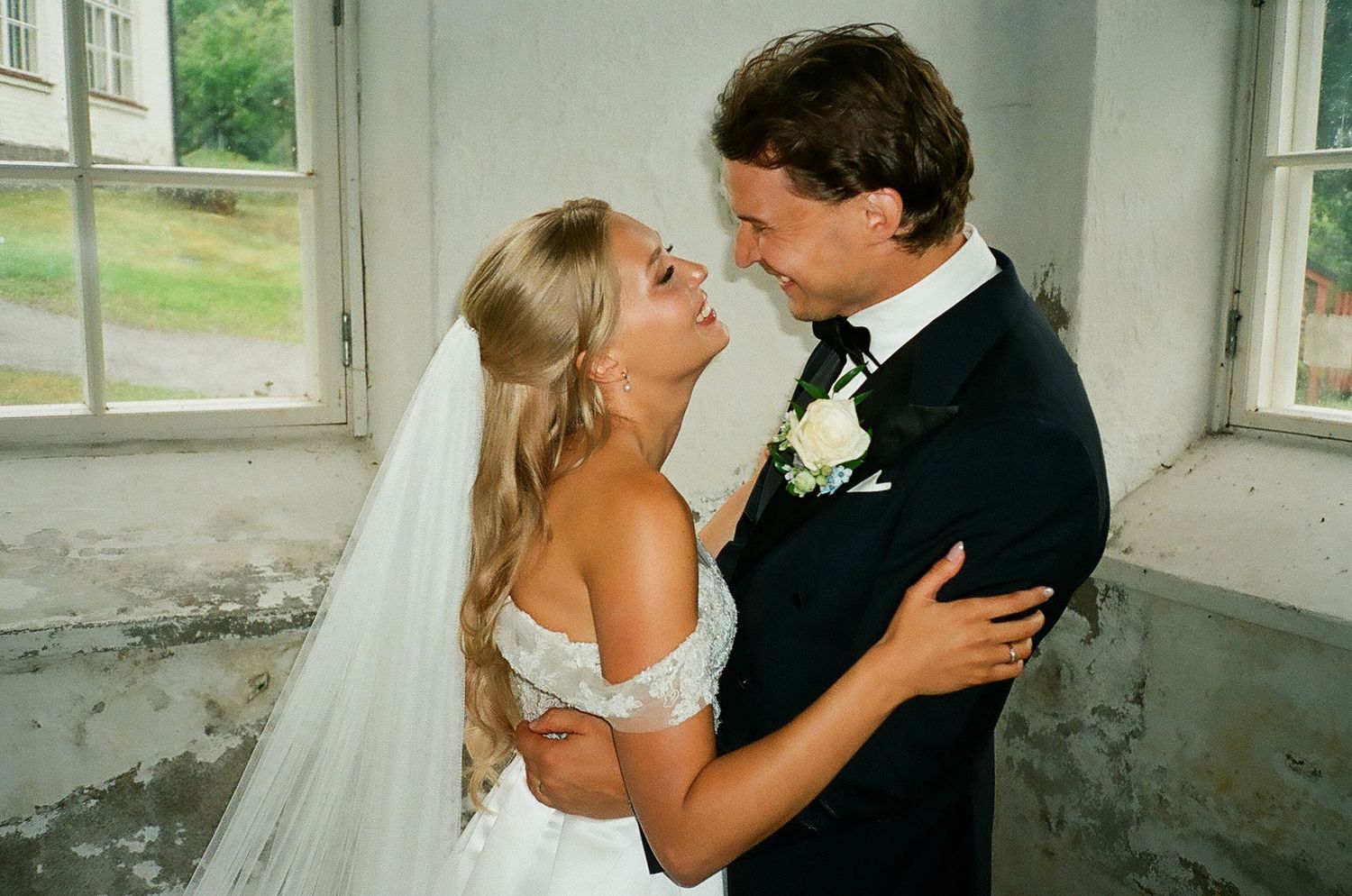 A romantic wedding moment captured in a series of tender embraces by a window.