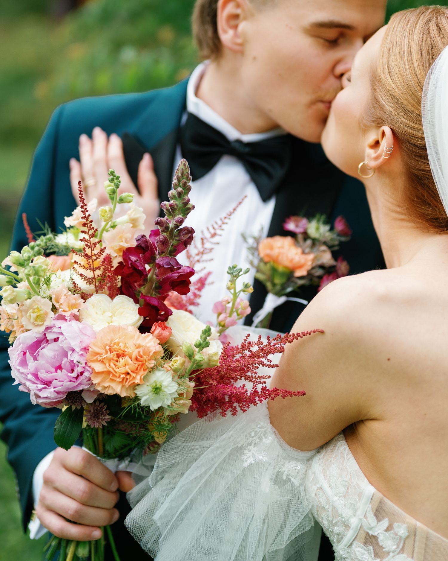 Elegant wedding portrait with bride holding beautiful multicolored bouquet.