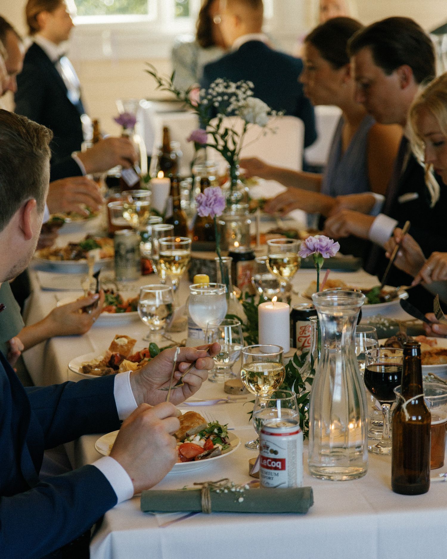 Wedding reception table settings with wine glasses and candlelight decorations.