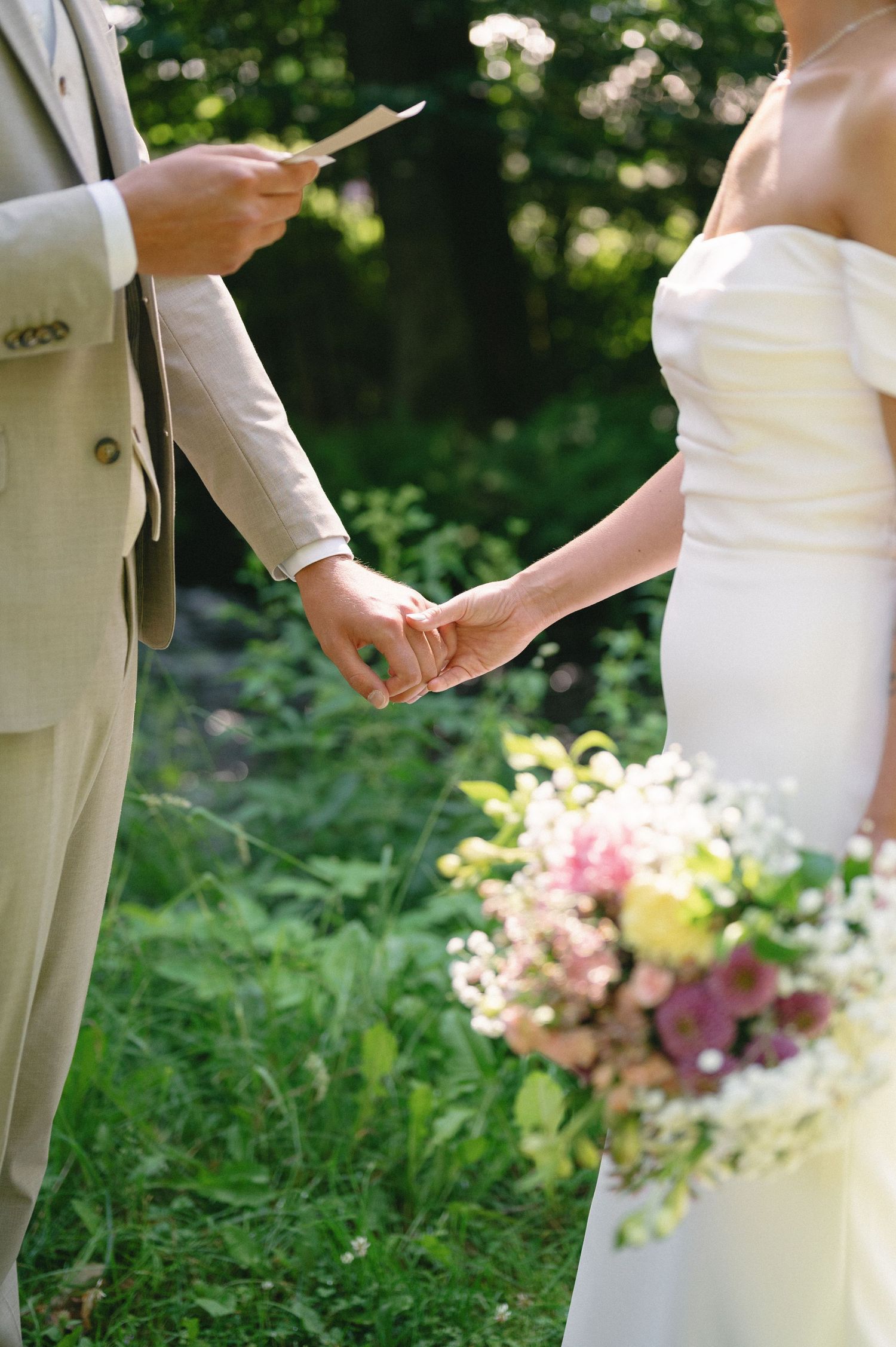 Wedding couple exchanging vows surrounded by colorful garden flowers.