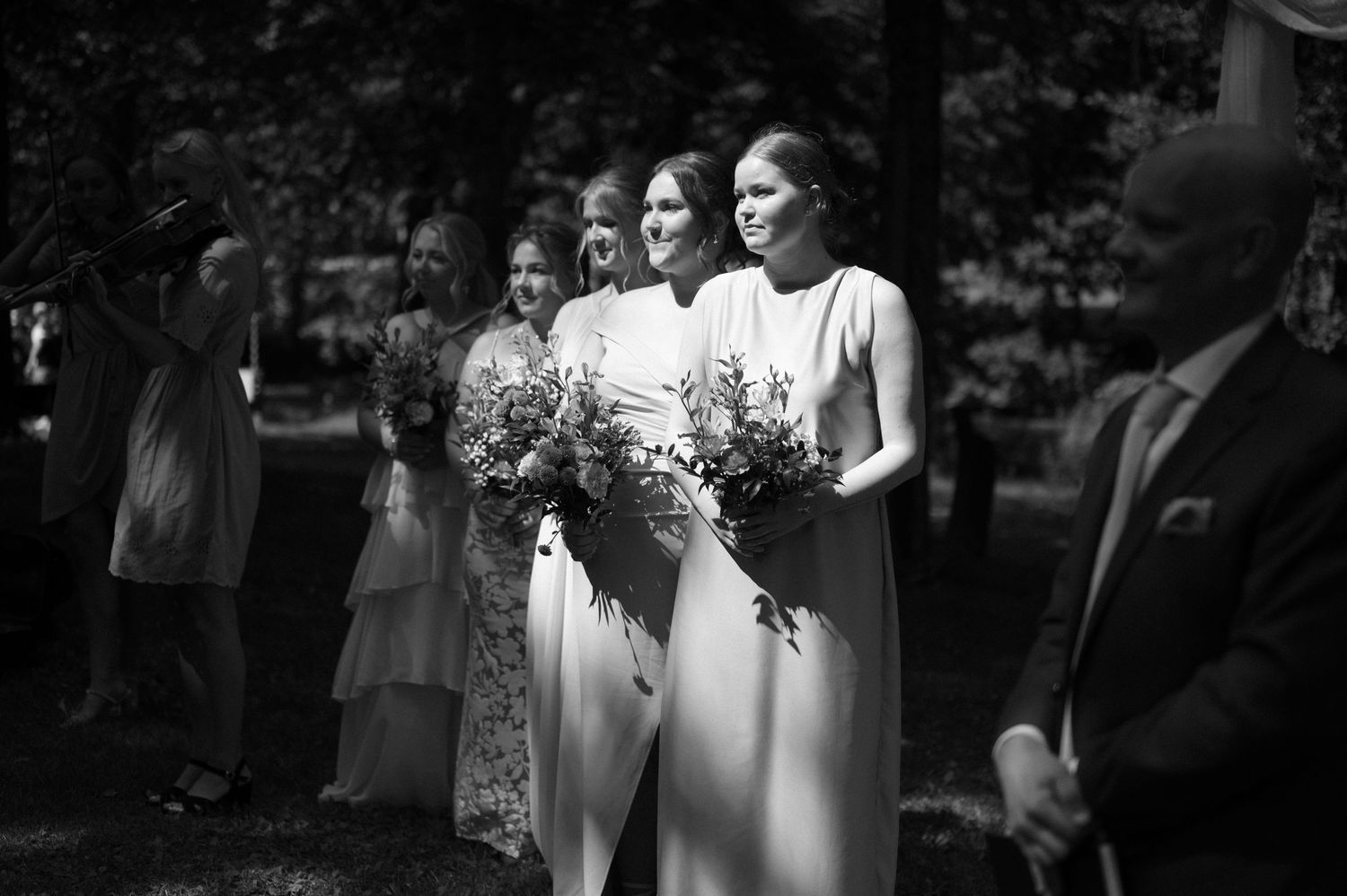 Black and white candid shots of wedding guests during an outdoor ceremony.