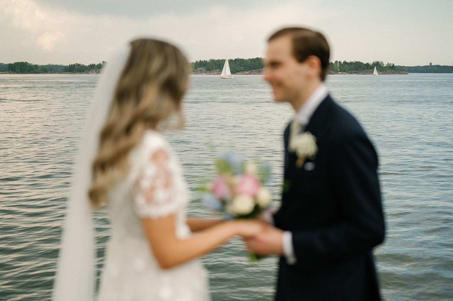 Romantic waterfront scene with sailboats in the background.