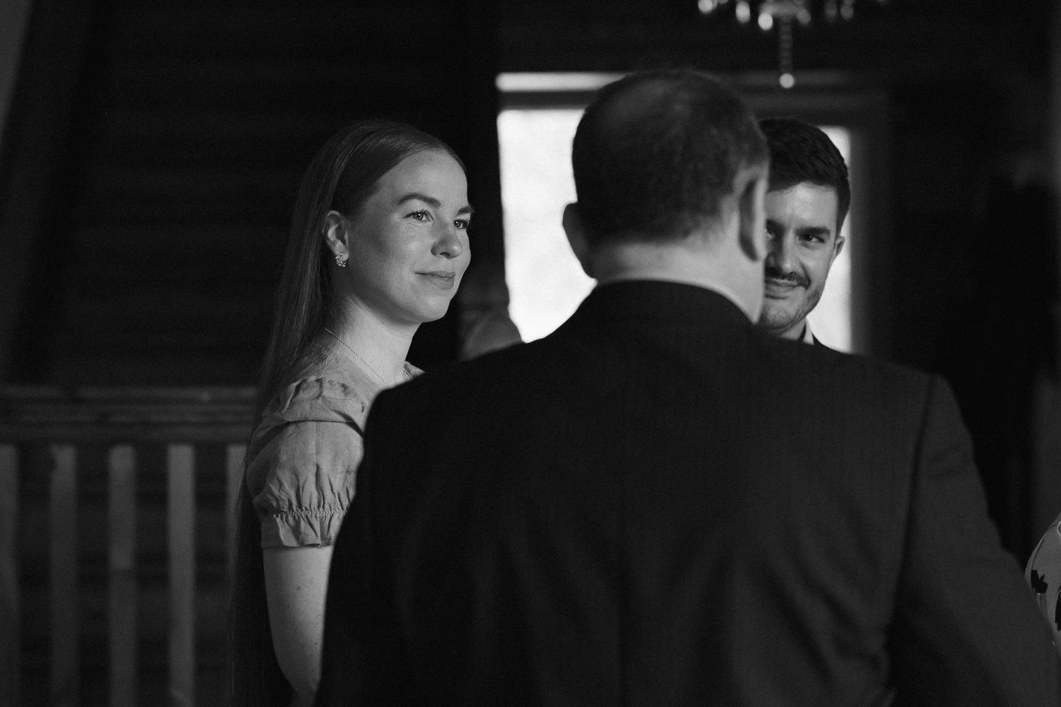 Elegant reception gathering in dark ambient lighting with guests mingling.