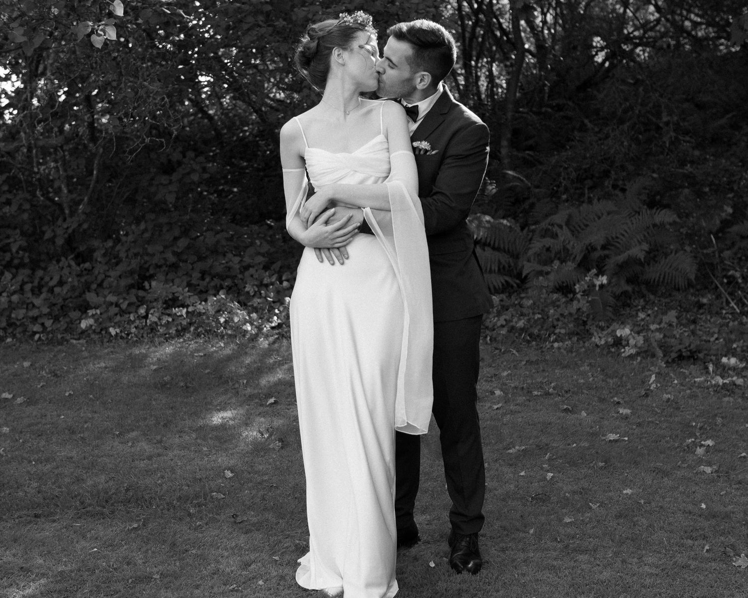 Intimate black and white wedding portraits captured in a garden setting.