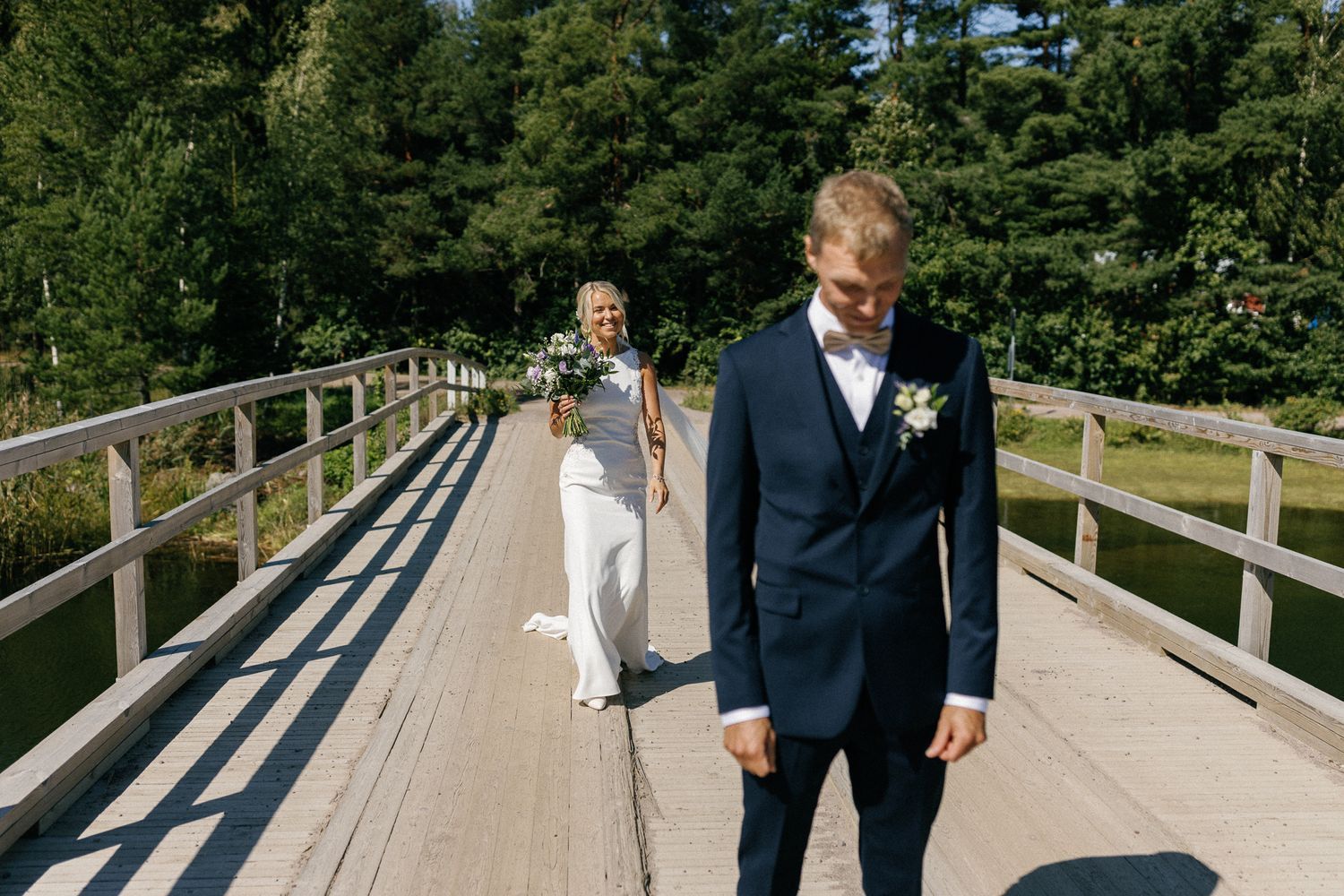 A rustic wooden boardwalk path surrounded by tall evergreen trees.