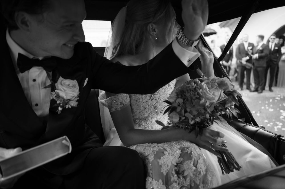 Intimate black and white moment during confetti toss at church wedding.