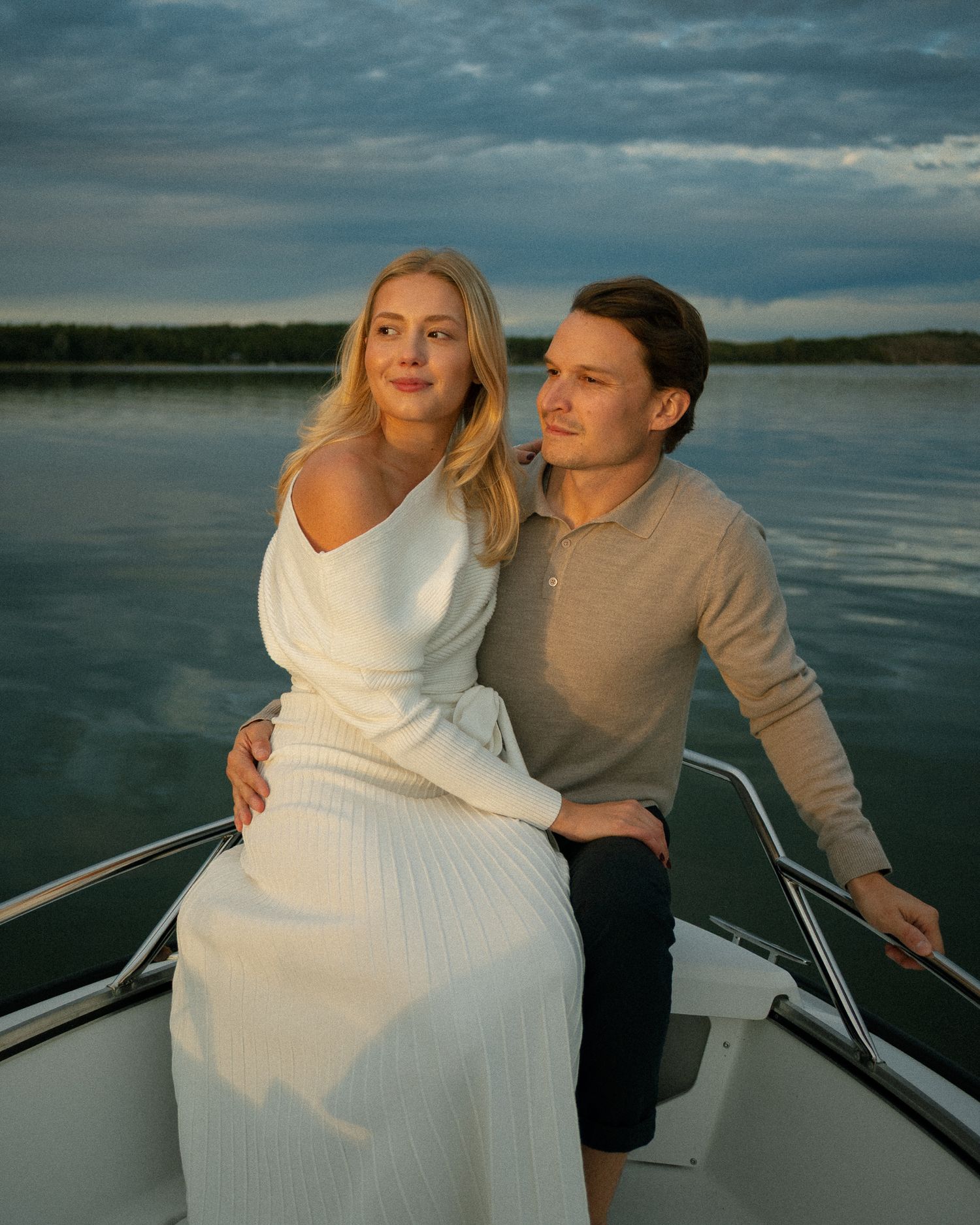 Romantic boat ride featuring a couple in white and grey clothing against moody skies.