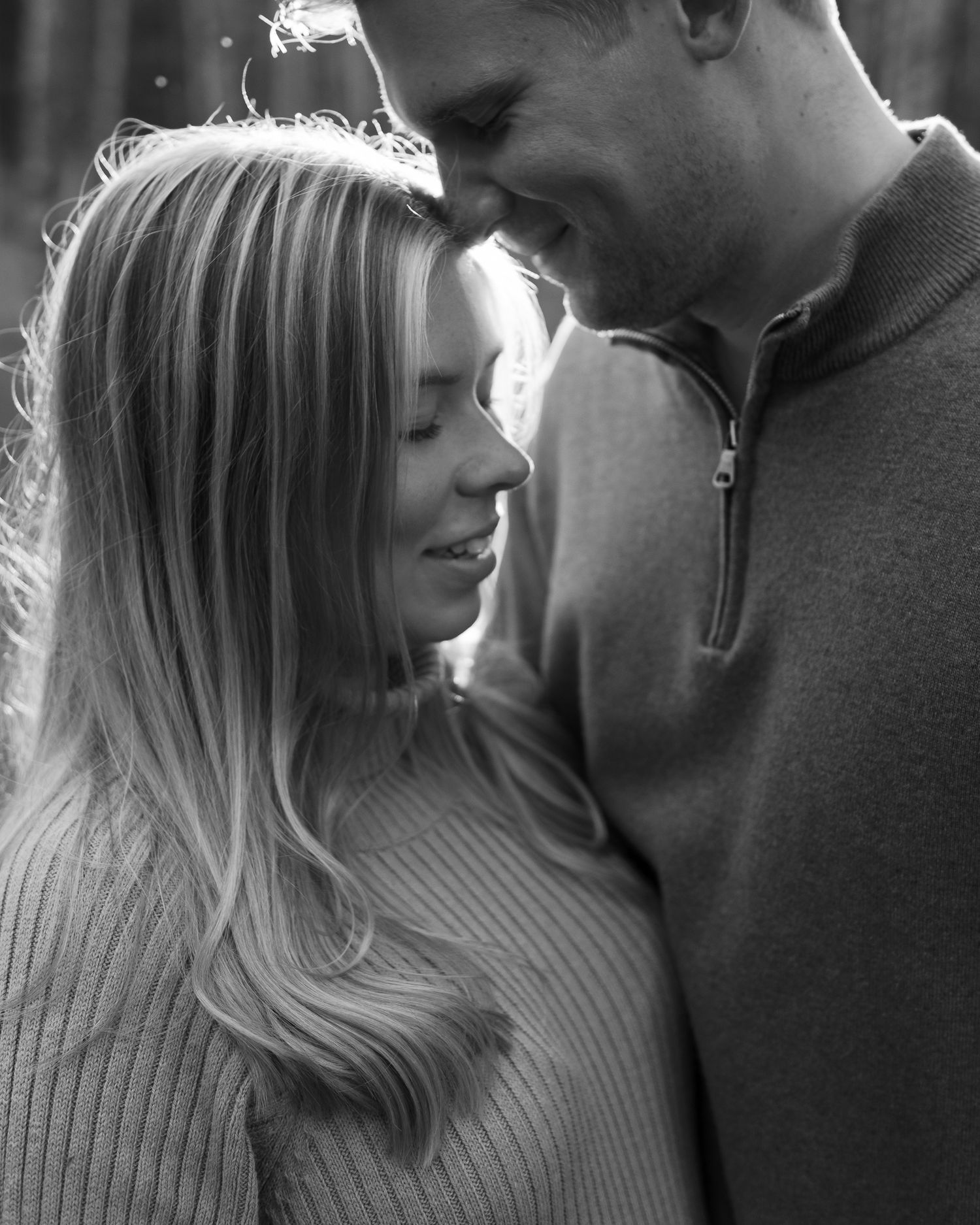 Black and white intimate portraits of a couple in soft lighting.