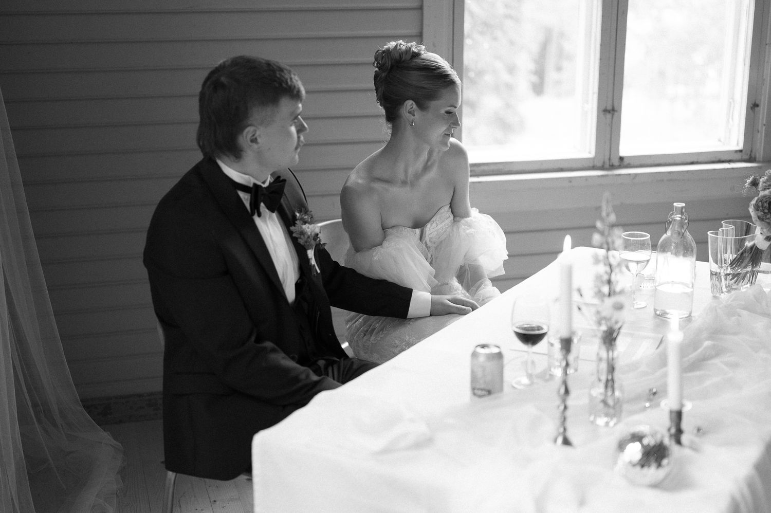 Intimate wedding reception dinner scene with formal place settings and romantic lighting.