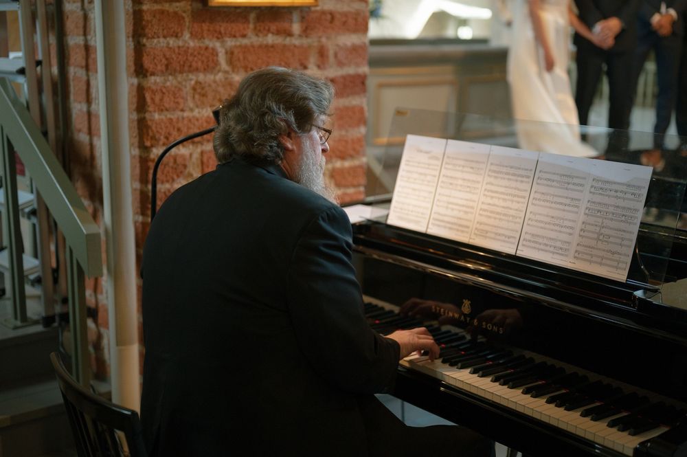 A pianist performs at a grand piano during an elegant church wedding ceremony.
