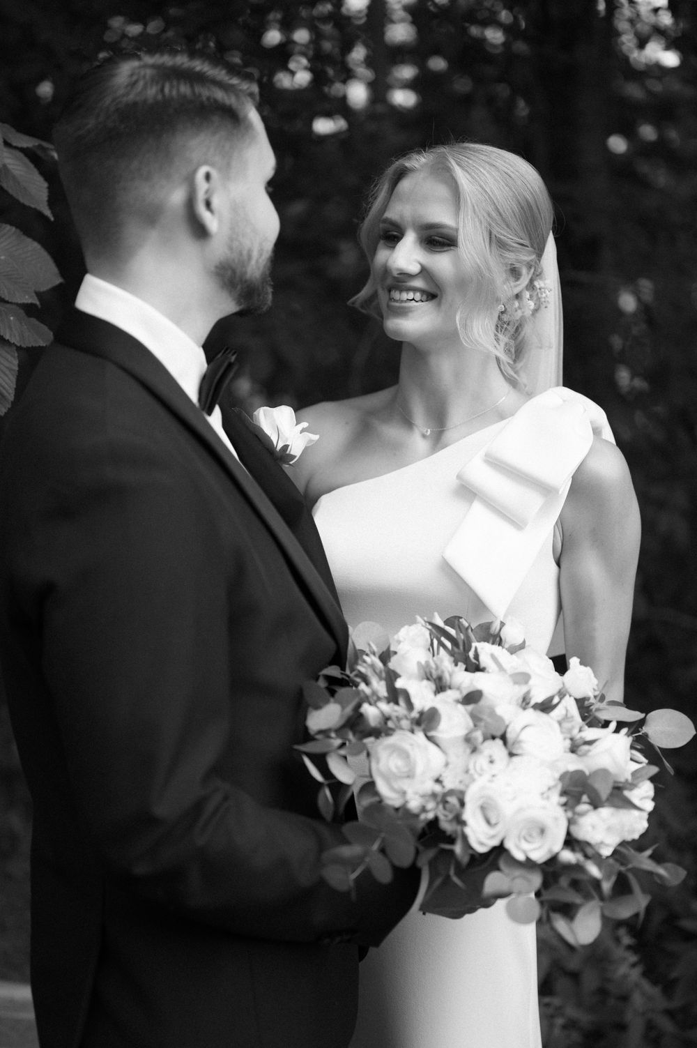 Candid black and white wedding photos capturing joyful moments with white floral bouquet.