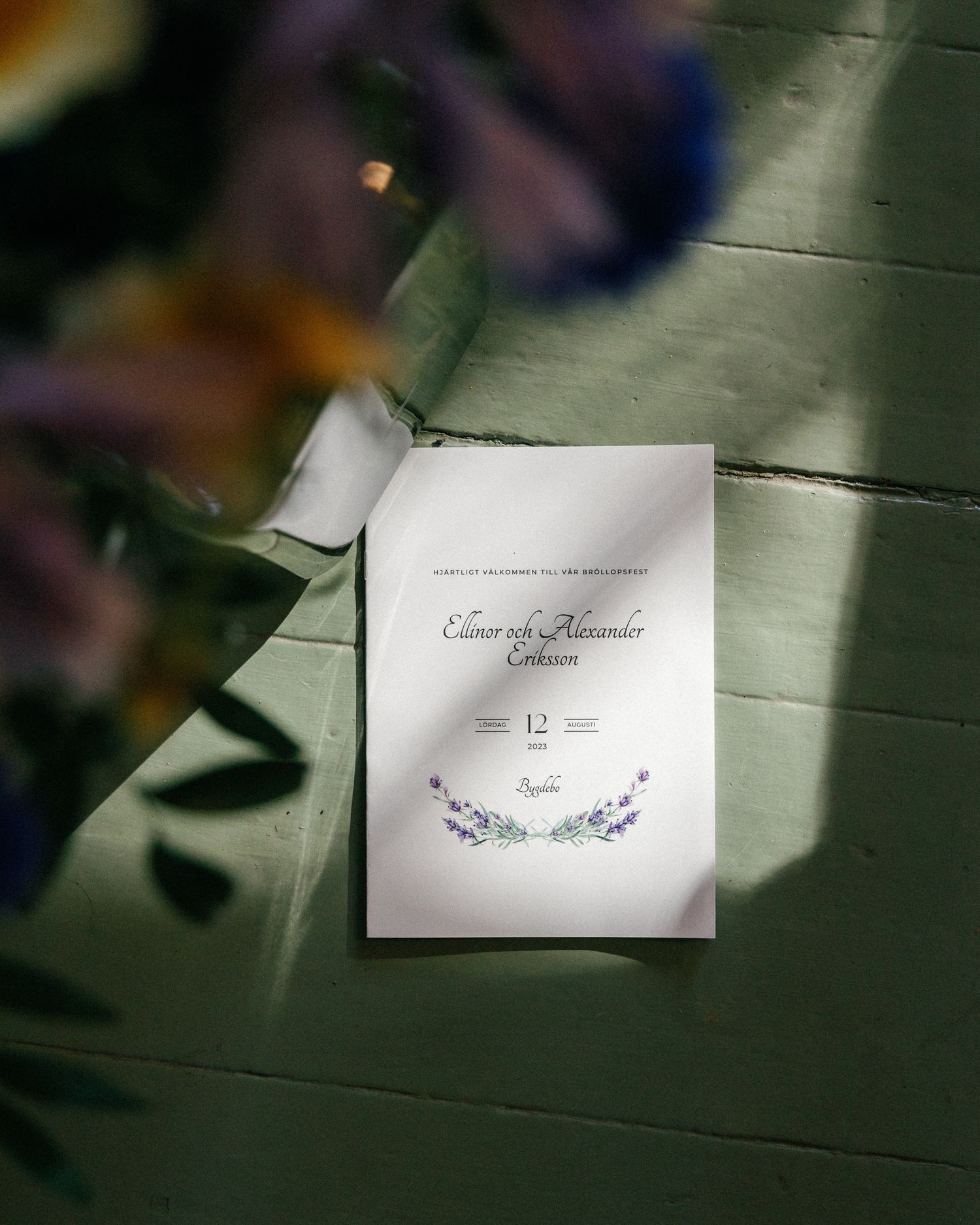 Wedding place cards with floral designs photographed in dramatic lighting.