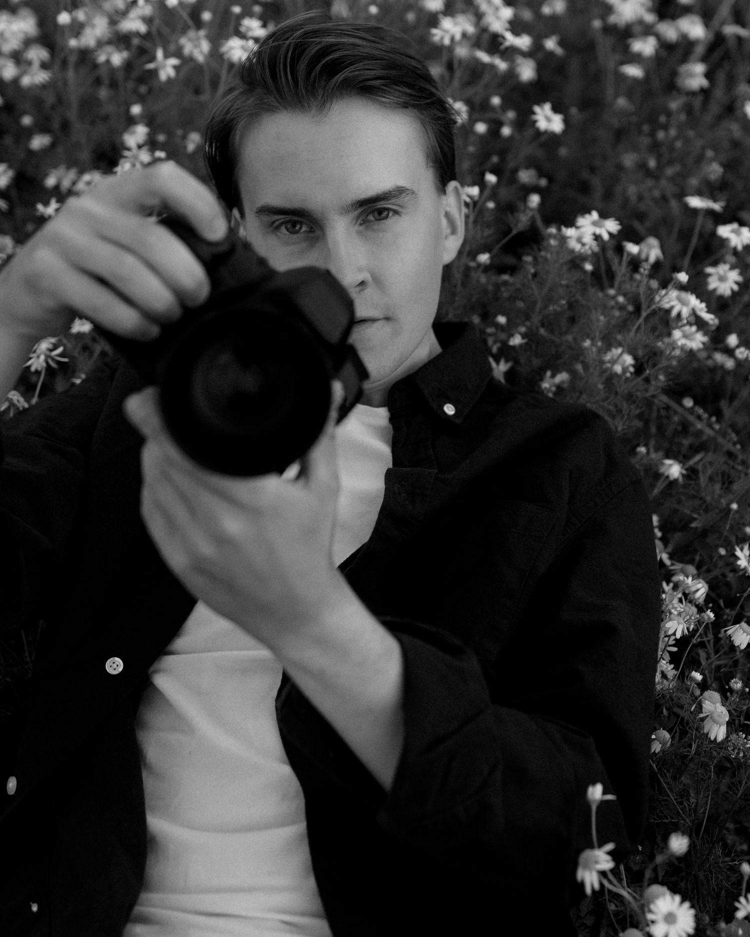 Black and white sequence of couple posing among blooming flowers.
