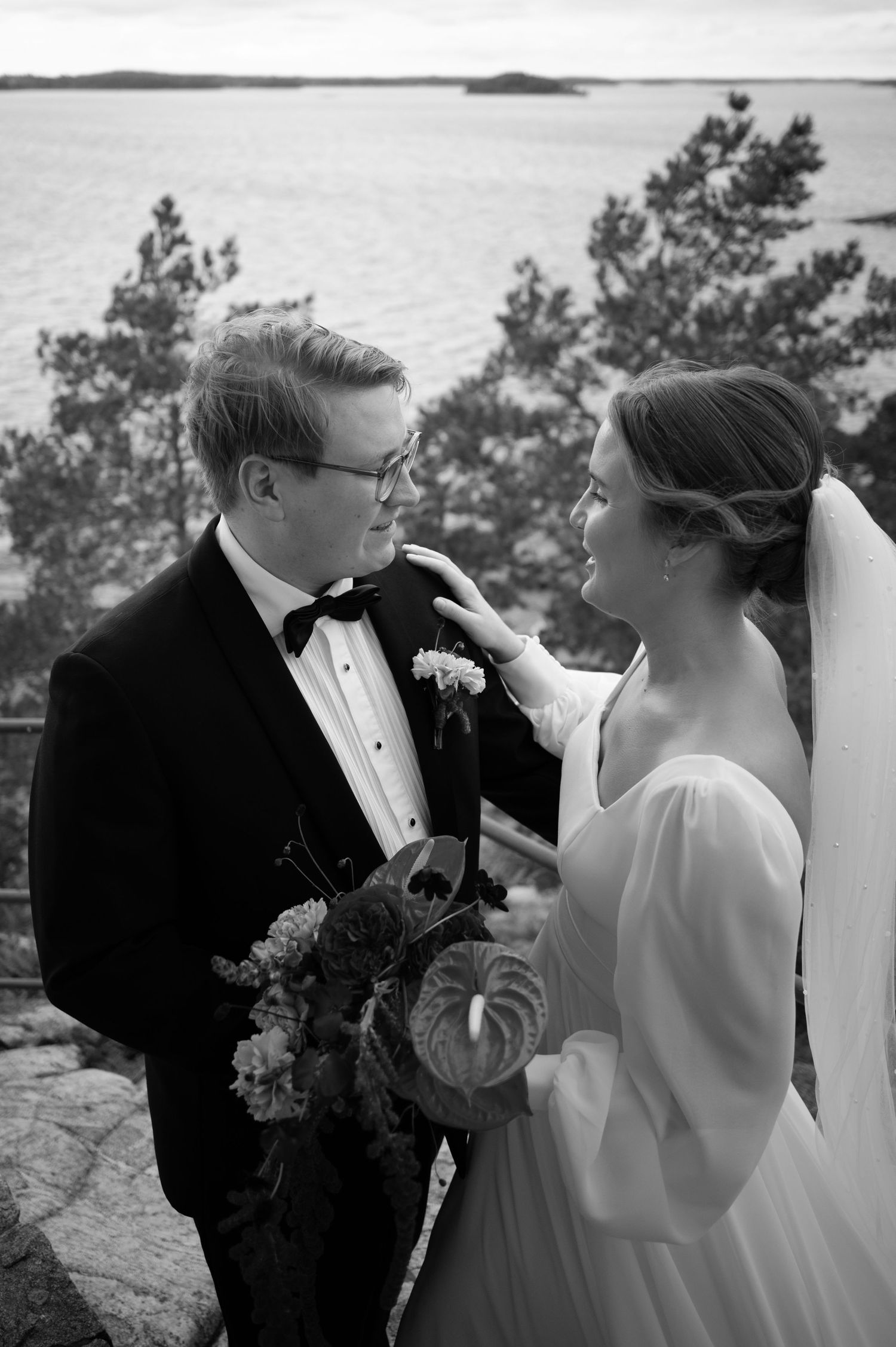 A romantic black and white wedding sequence shows a couple sharing intimate moments together outdoors.