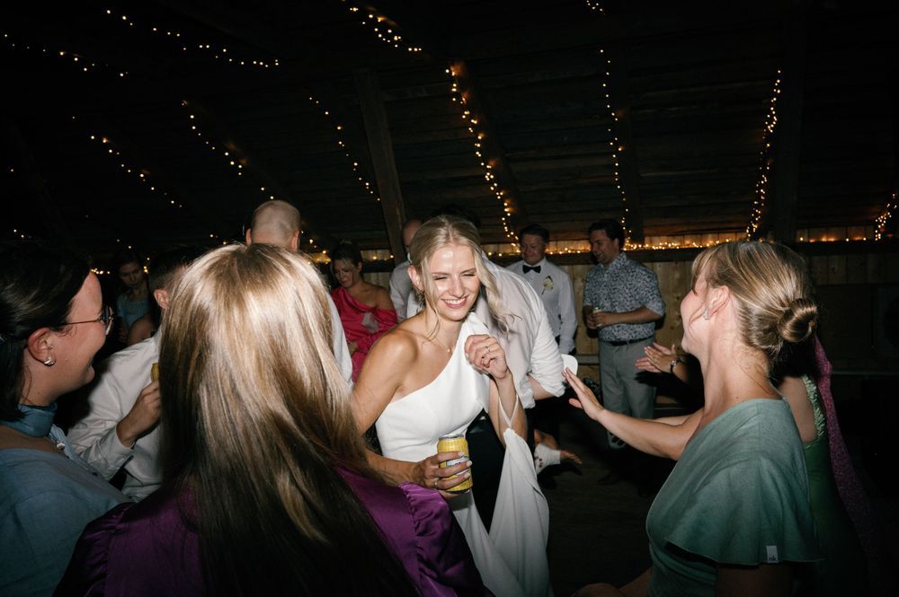Party guests dancing under string lights at a nighttime celebration.