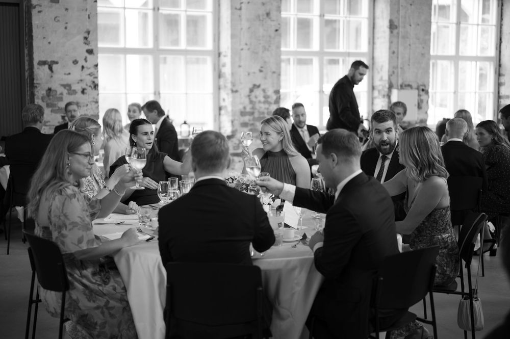 Guests enjoying a formal dining event in an industrial-style venue with exposed brick walls.