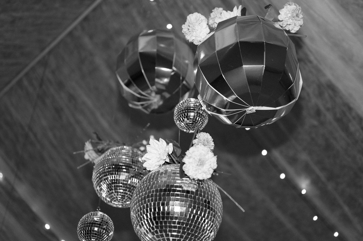 Disco balls and floral decorations create a festive atmosphere at a wedding reception.