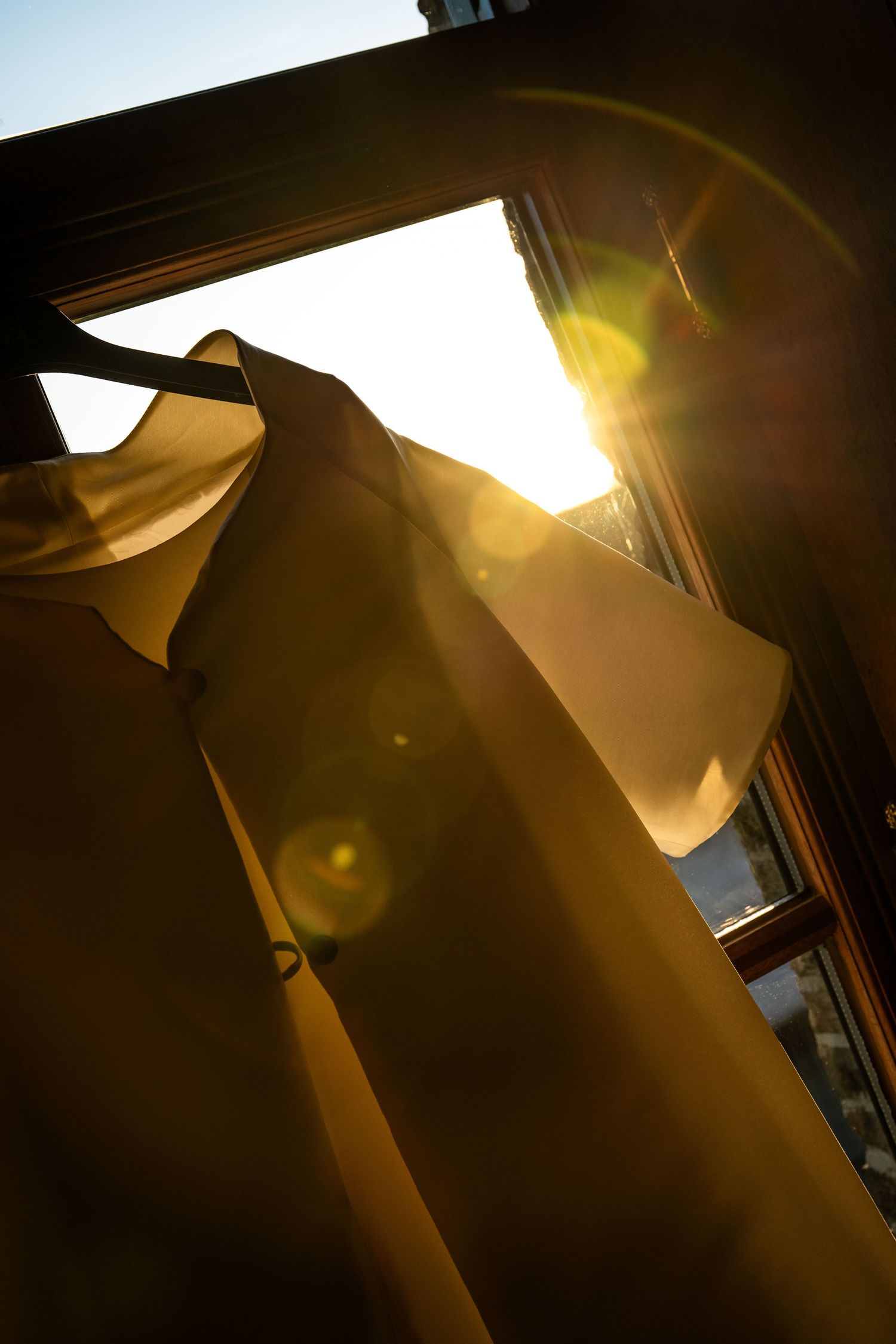 Trouwkleed aan de ruit met zonsopgang
