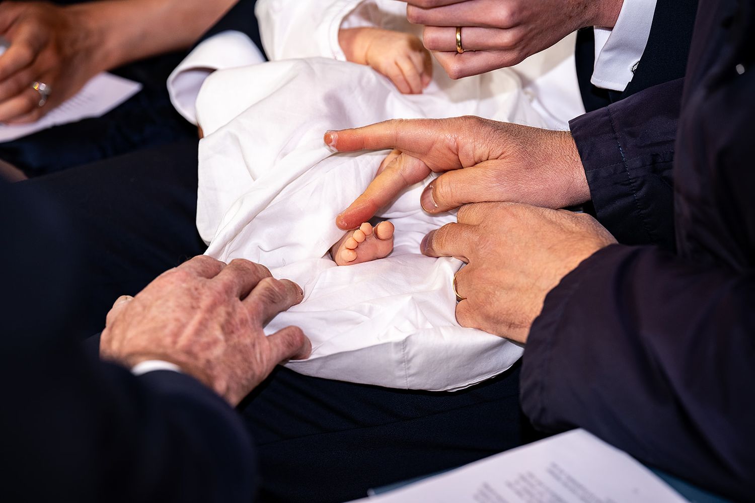 Doopsel fotografie -  inwrijven met zalf aan de voetjes gefotografeerd - kerk van Gits