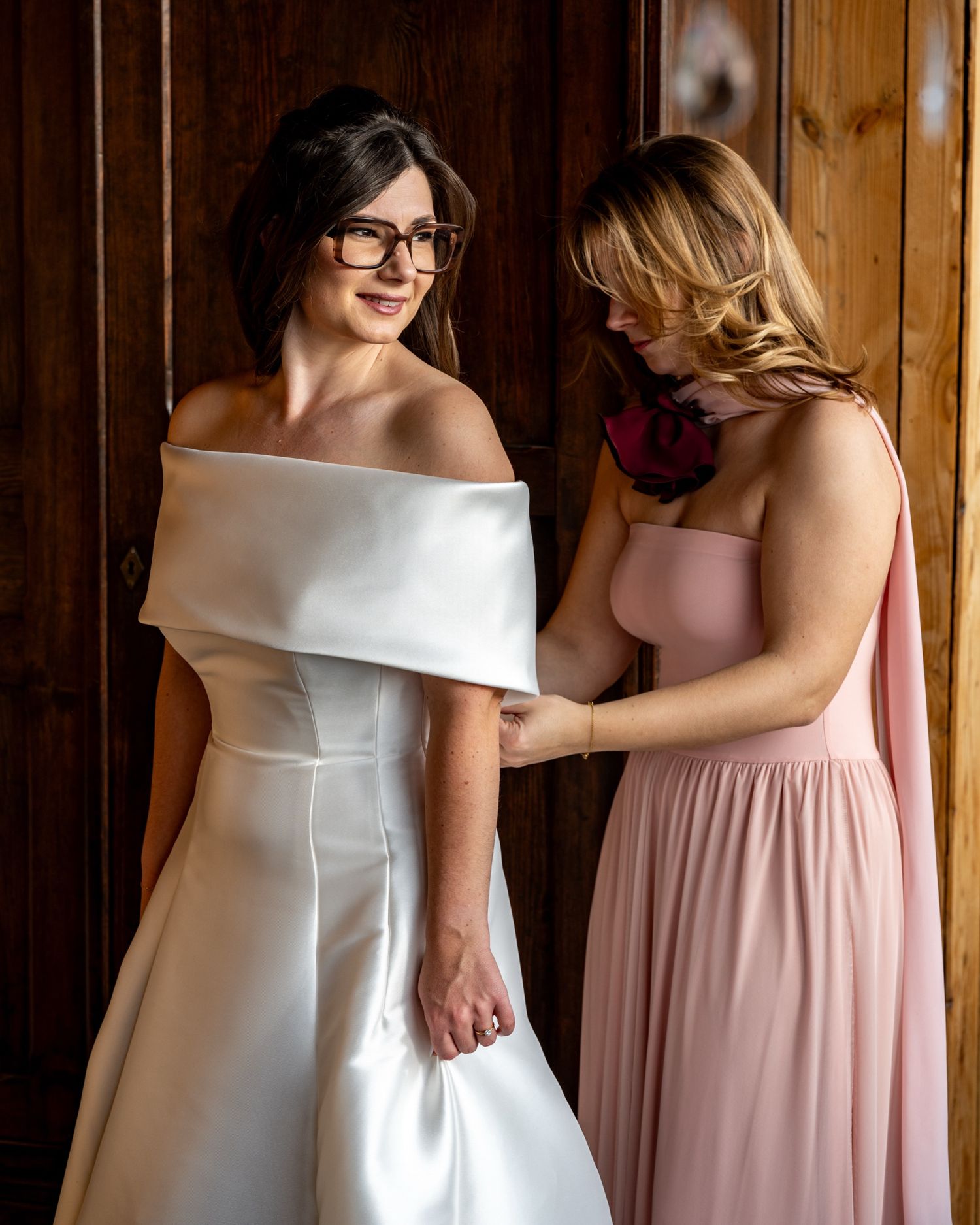 Intieme fotografie huwelijksshoot in Domein Eikennest te Diksmuide, zus helpt haar zus haar trouwkleed dichtdoen