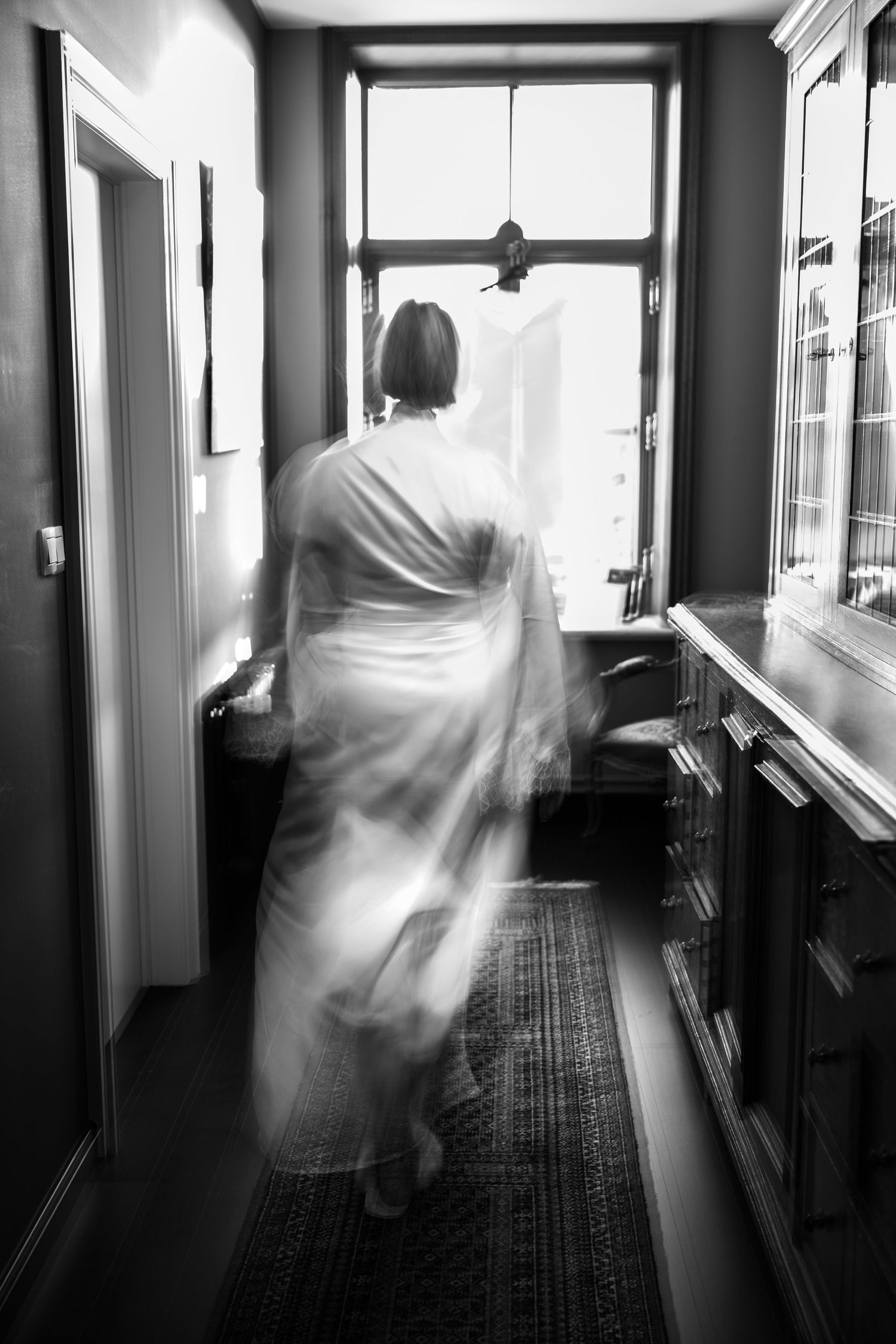 Bruid gefotografeerd in satijnen kamerjas met zachte blur
