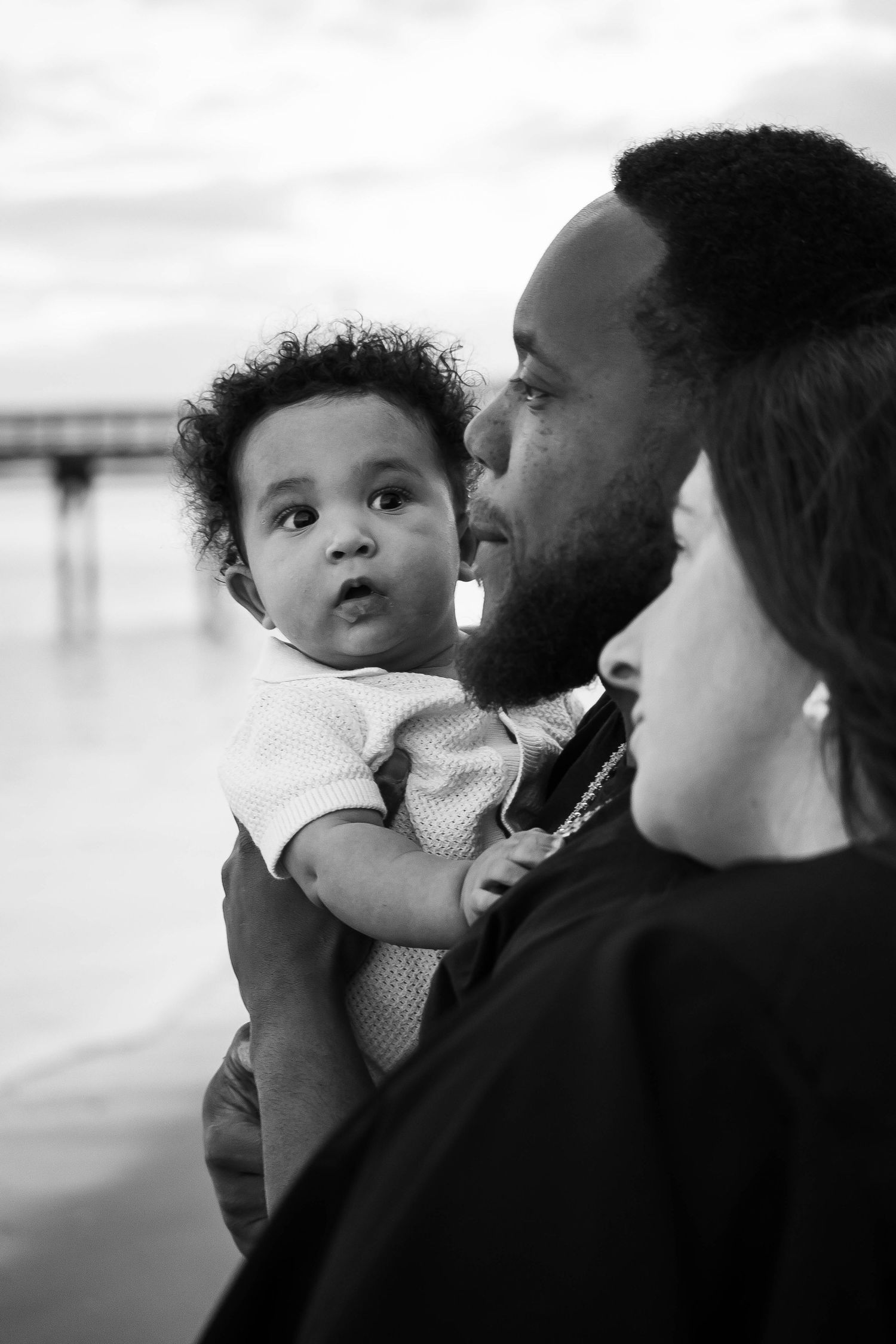 A series of black and white photos showing tender moments between parent and child against a simple background.