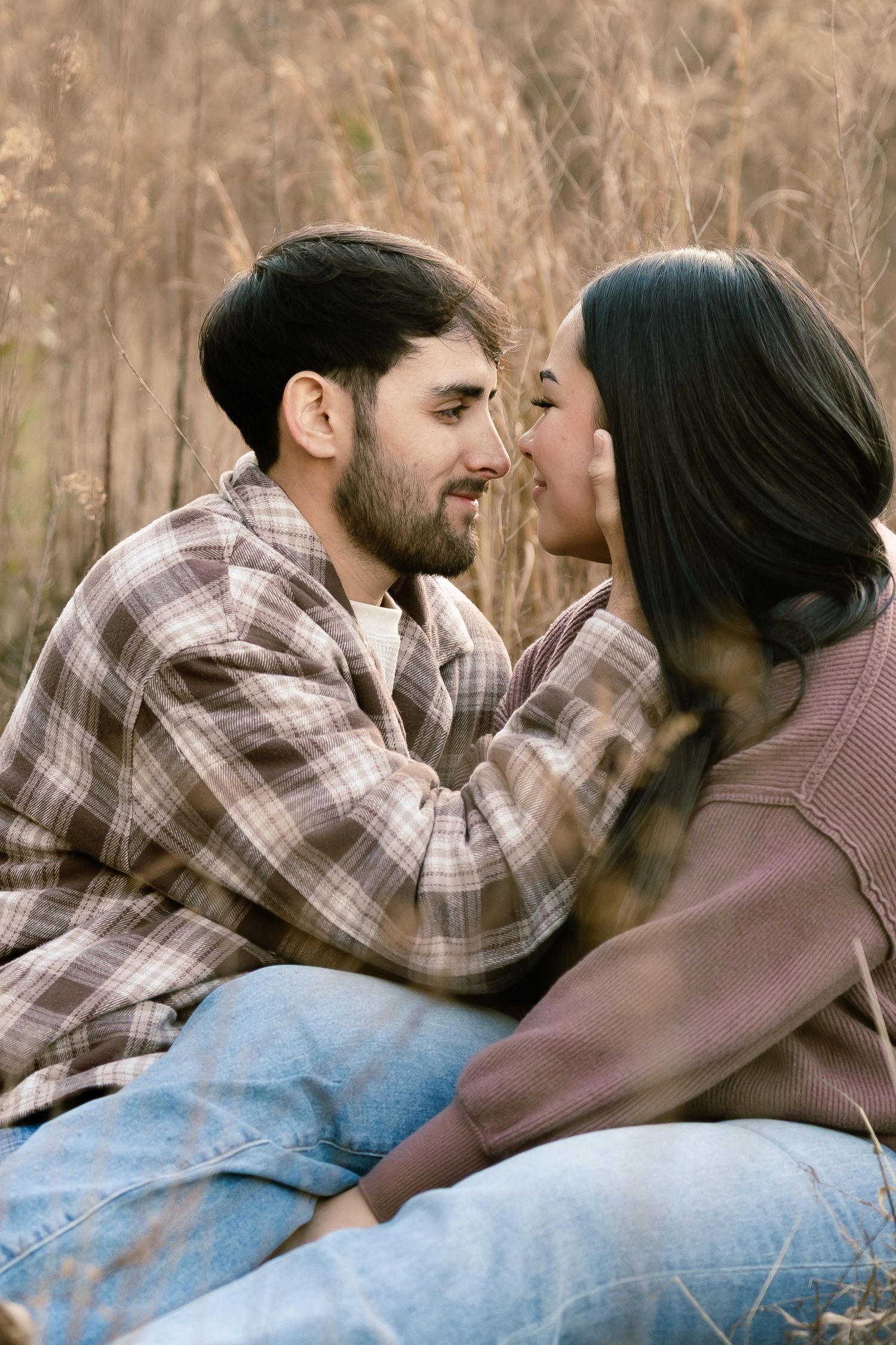 Romantic couple sharing intimate moments on blanket outdoors.