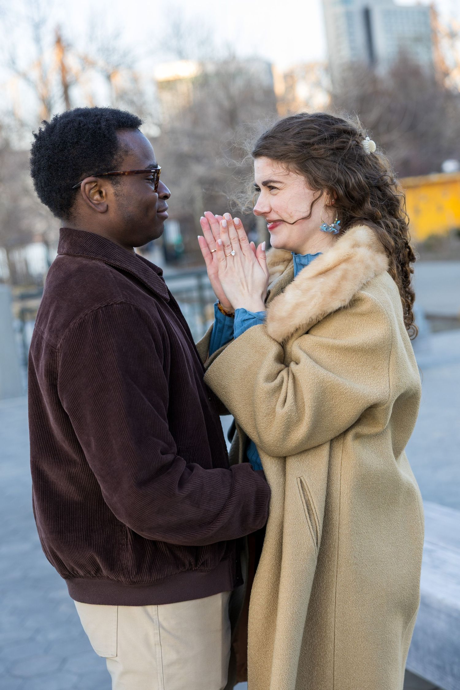Engaged couple posing with NYC skyline after proposal