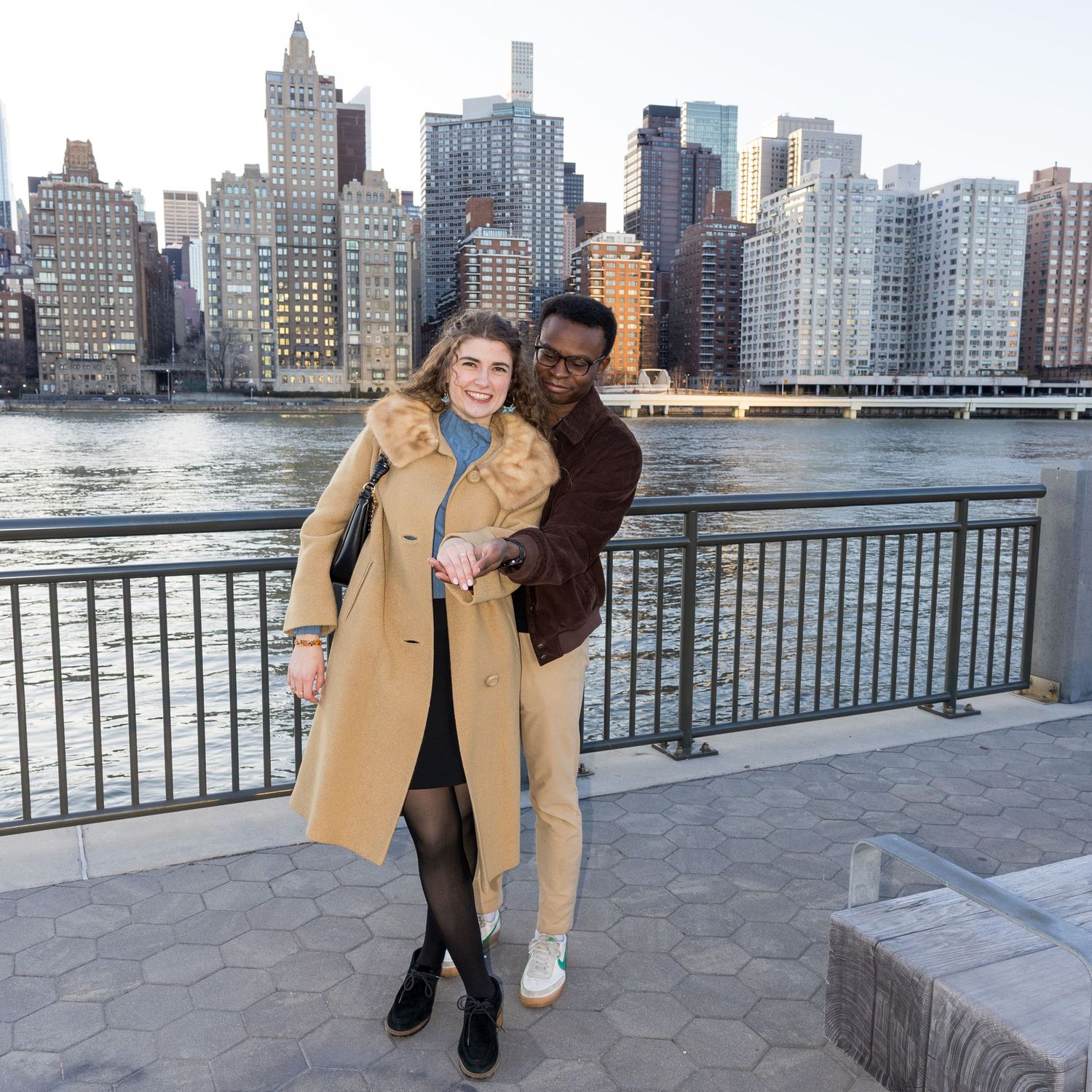 Engaged couple posing with NYC skyline after proposal