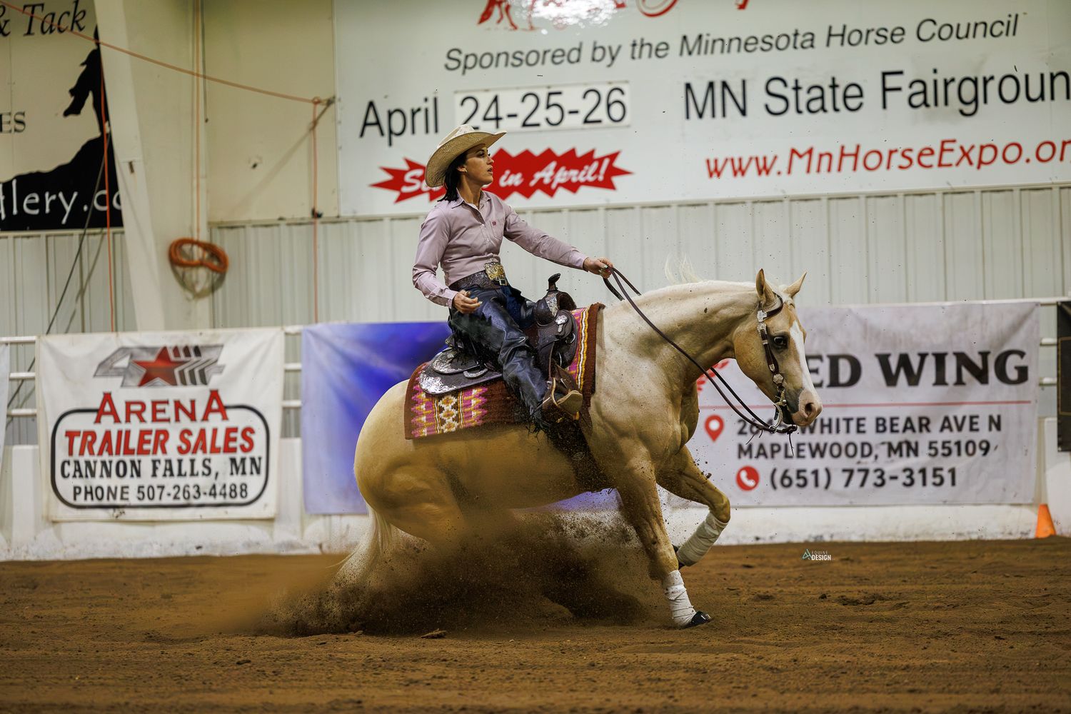 A rider on a palomino horse performs a sliding stop at the MN Horse Expo at the Minnesota State Fairground.