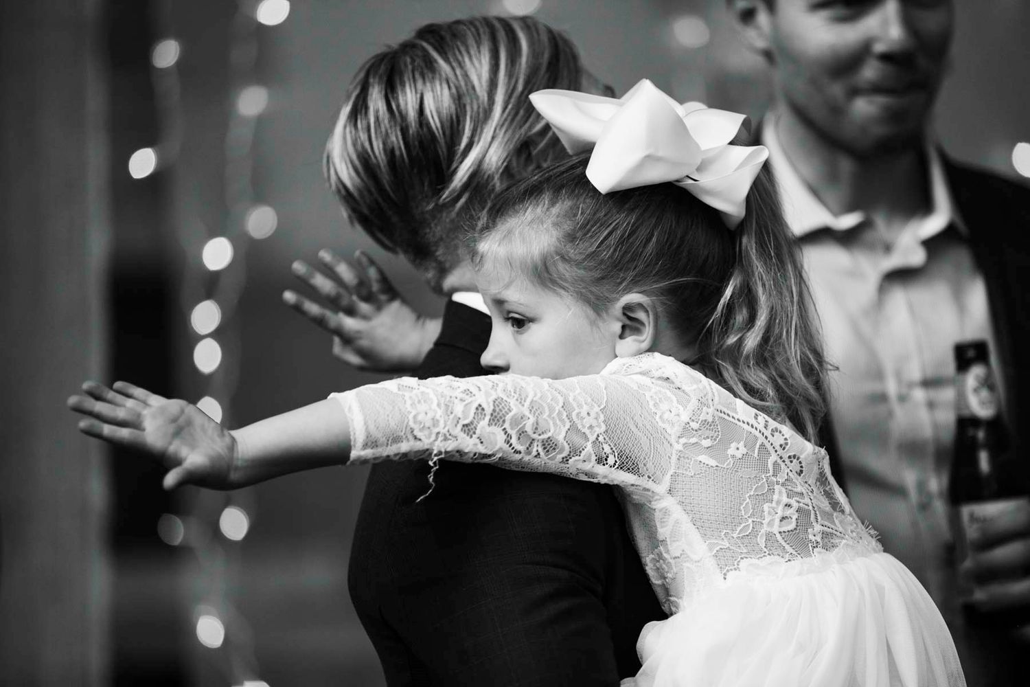 A couple shares a tender moment on their wedding day while dancing together under soft lighting.
