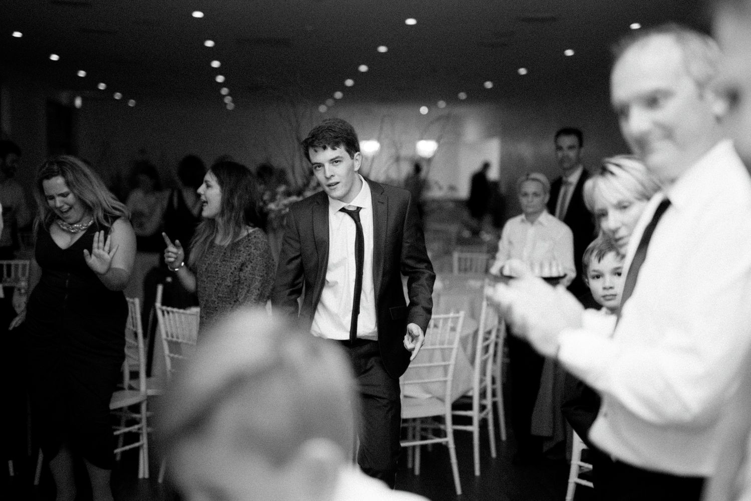 Black and white photos capture joyful dancing moments at a wedding reception.