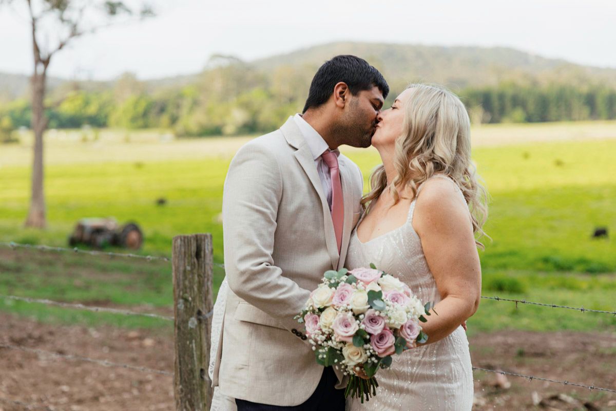 Romantic outdoor wedding photos featuring a couple embracing in a scenic field.