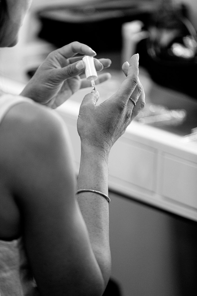 A series of black and white close-up photos showing hands holding small objects in a sequential progression.