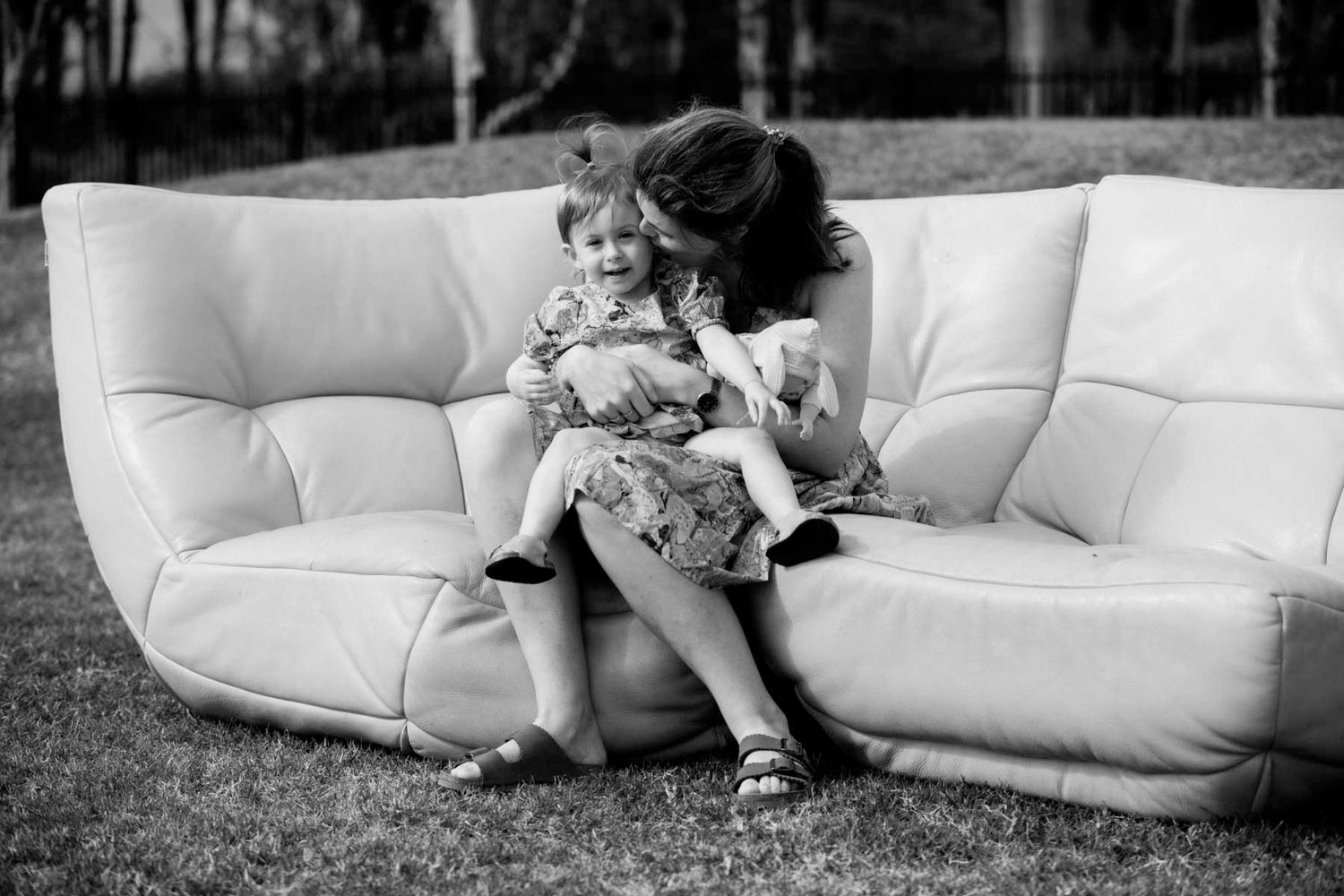 A sequence of black and white photos showing a person lounging and reading on a white couch outdoors.