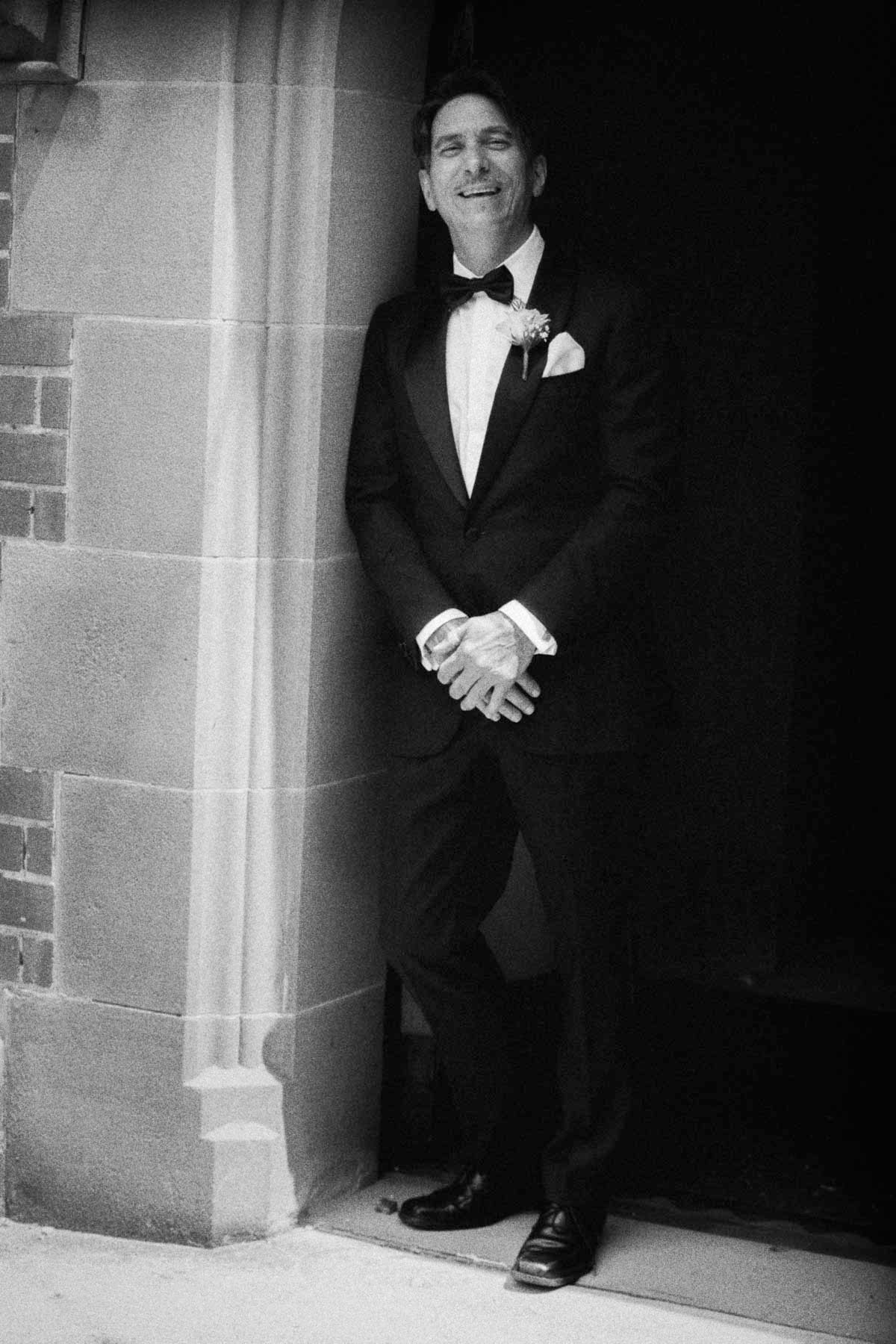 A series of black and white photos showing a person in a tuxedo posing in different angles against a brick wall.