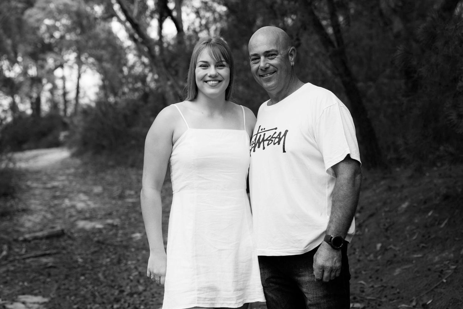 A couple poses together in a series of casual outdoor black and white portraits.