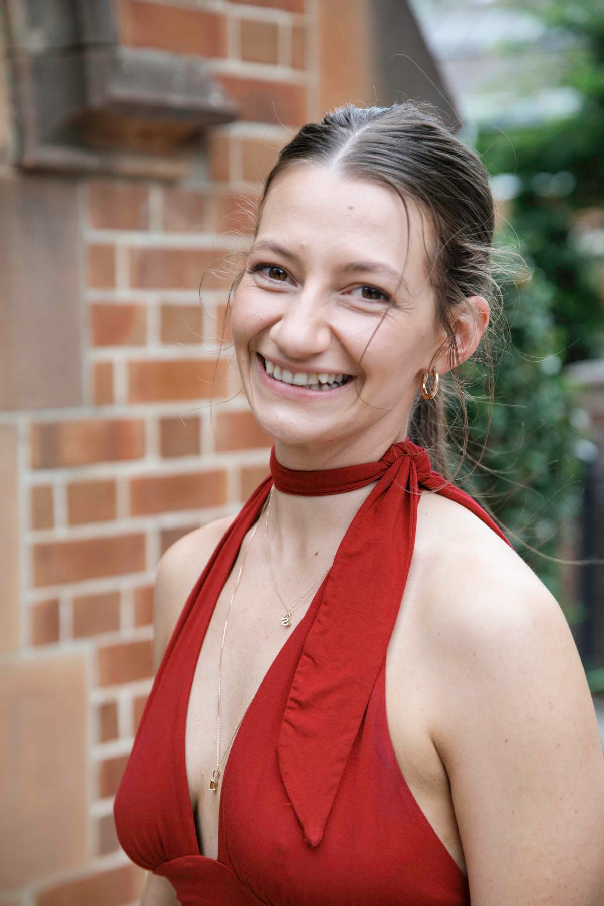 A sequence of photos showing someone in a red halter top smiling against a brick wall background.