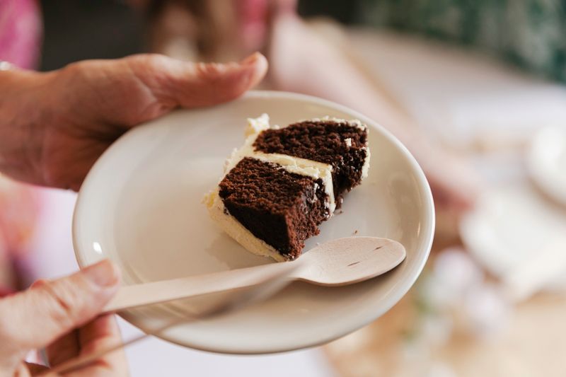 Slices of chocolate cake being served on white plates at an event.