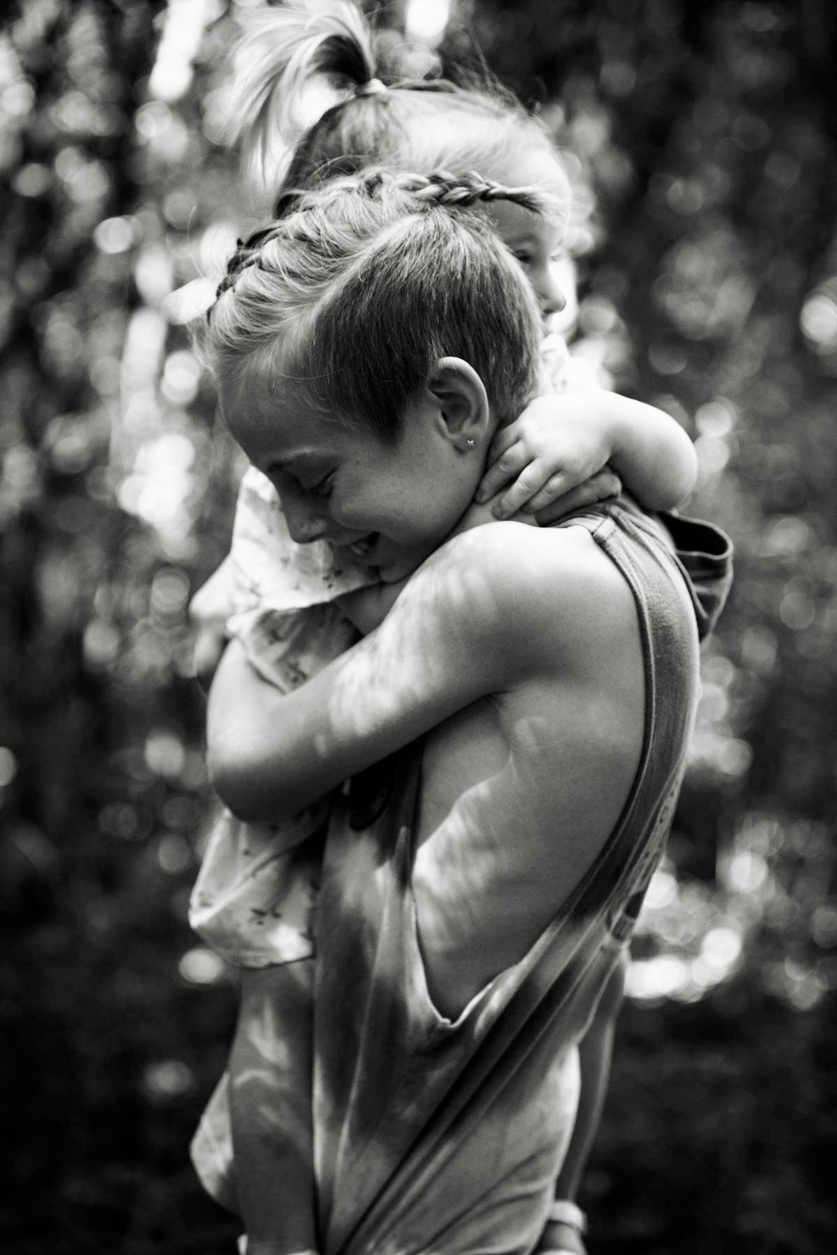 Black and white photo sequence showing a tender embrace between two people in a natural outdoor setting.