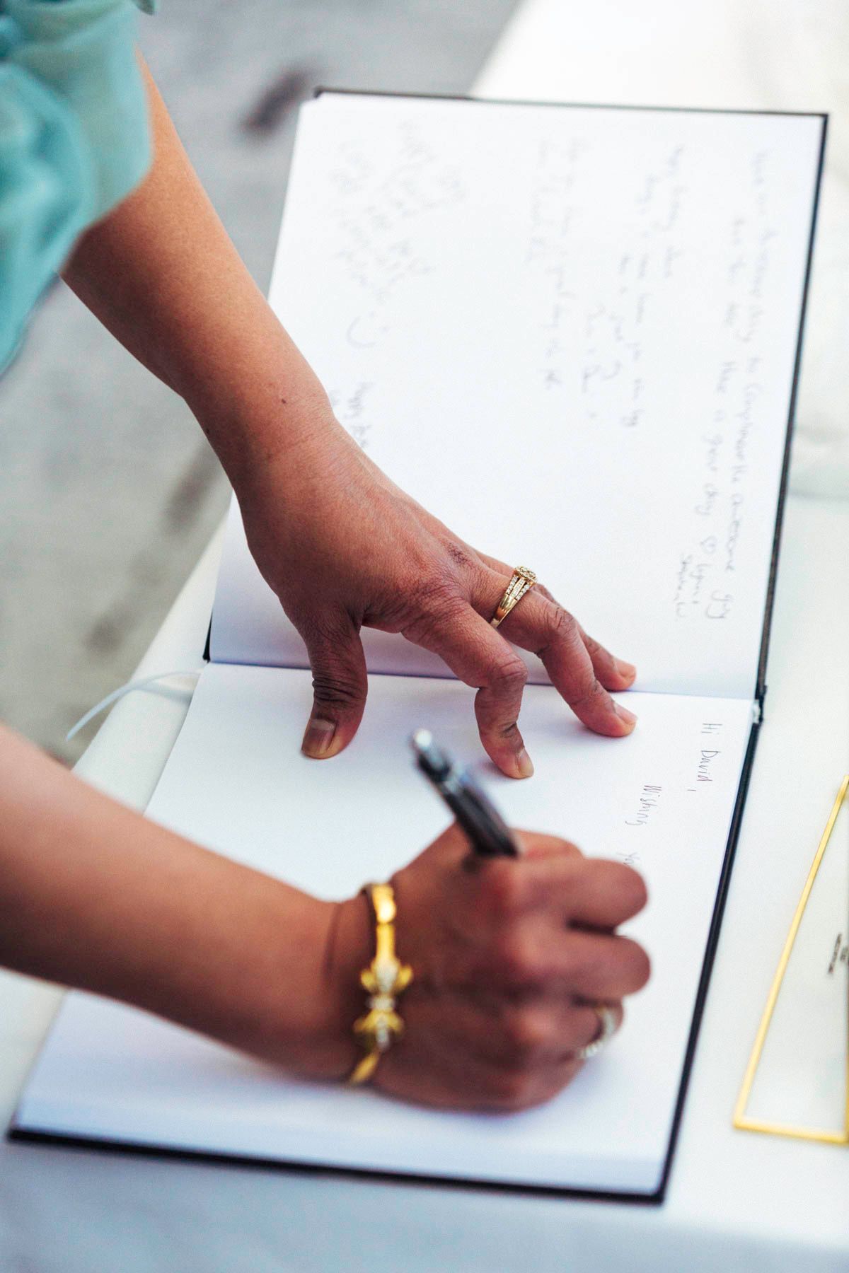 Close-up sequence of hands signing or writing in a document with a pen against white paper background.