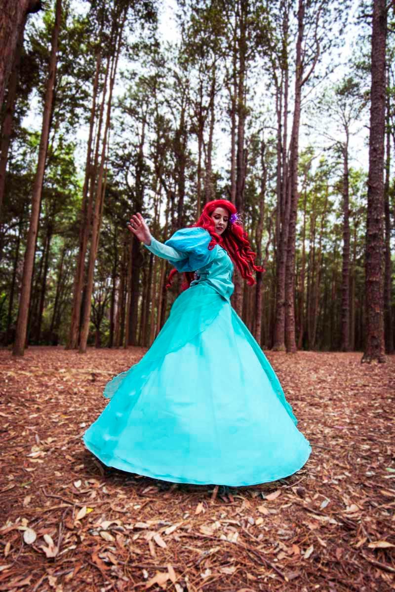 A sequence of four photos showing a turquoise ballgown dress twirling in a pine forest covered with fallen leaves.
