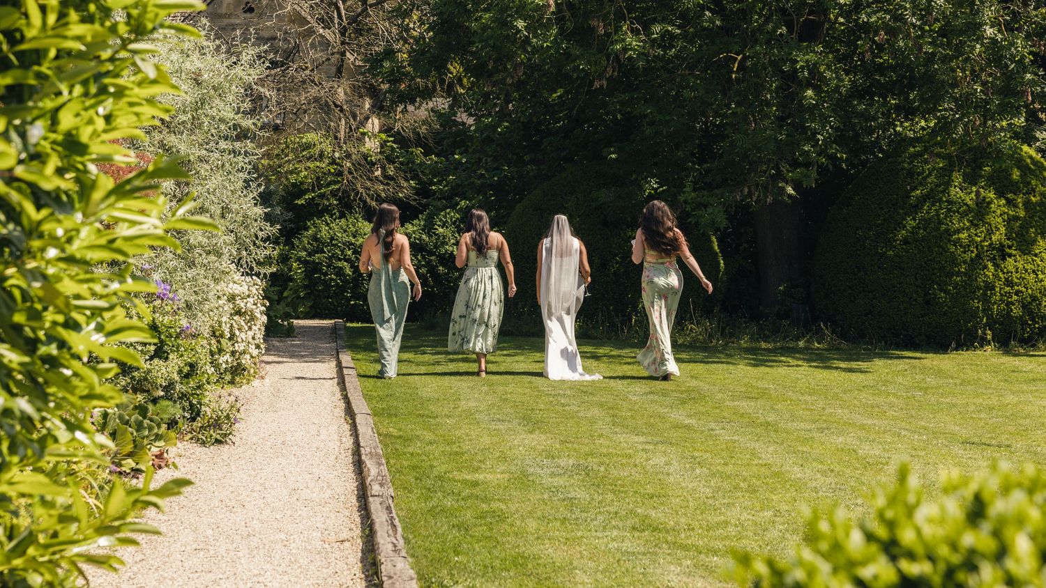A bride and her bridesmaids, heading off for a moment together during the wedding day celebrations, captured by EvieSJPhotography.