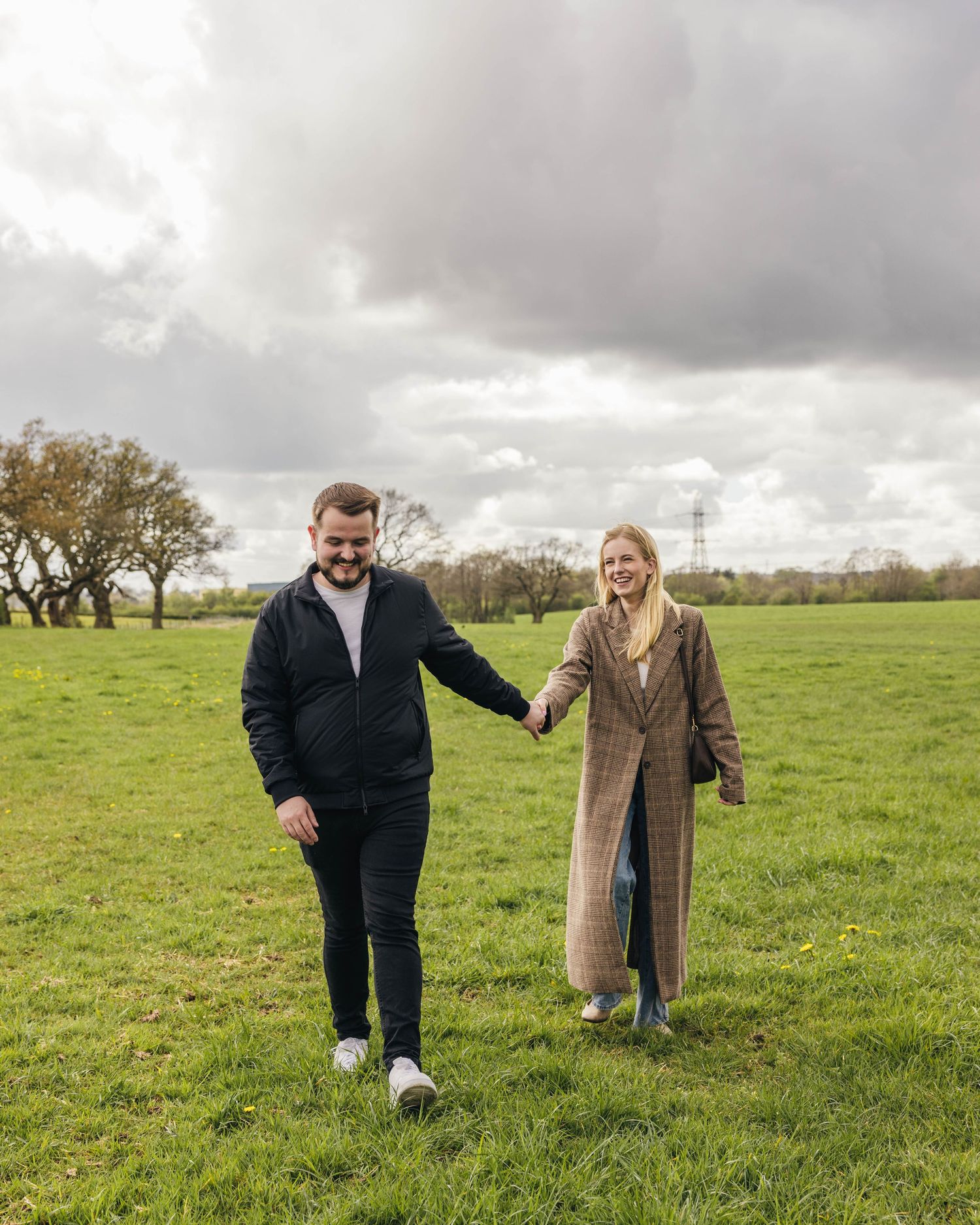 Natural engagement photoshoot of a couple in a field by EvieSJPhotography.