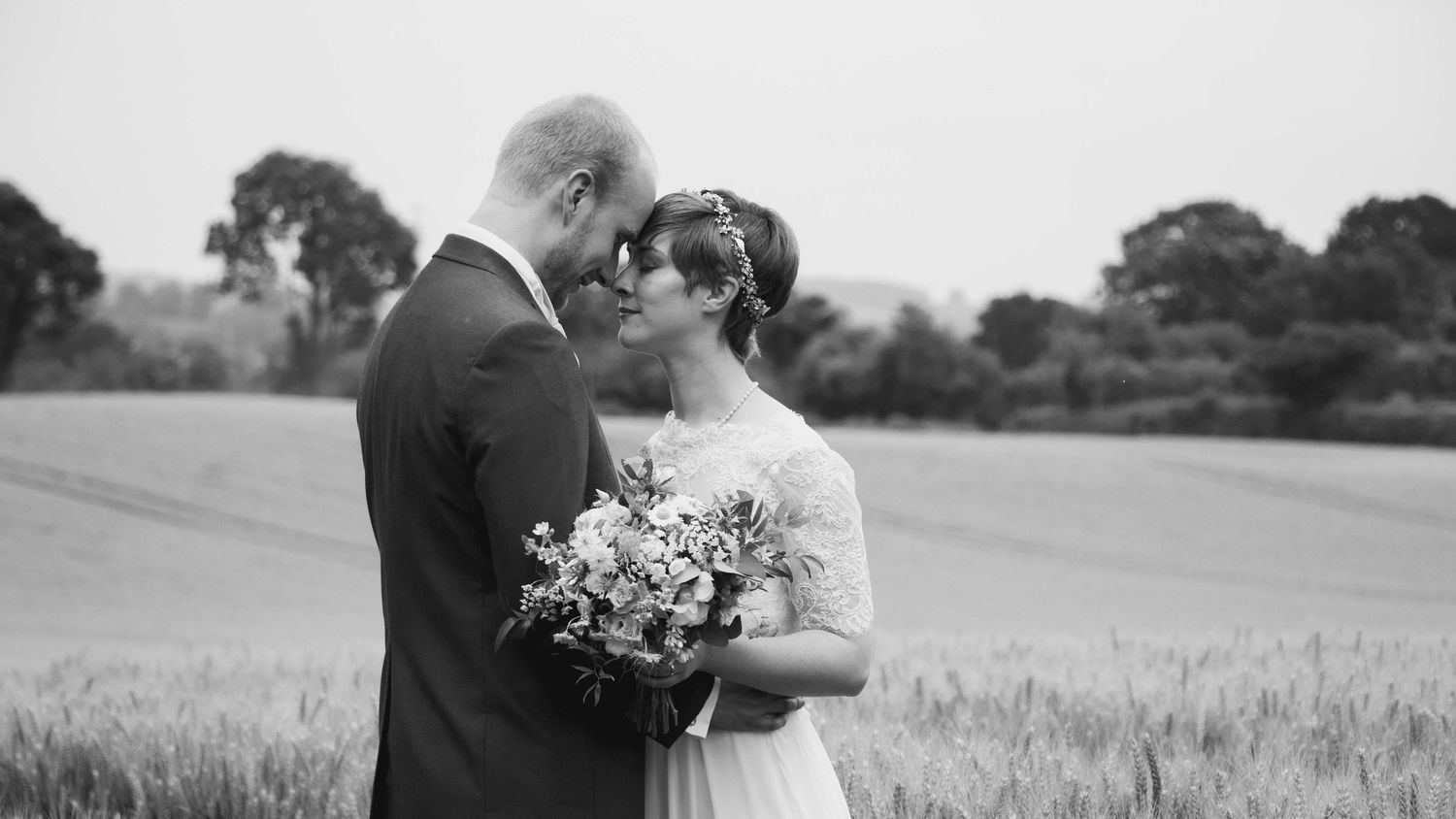 Bride and groom sharing a romantic moment on their wedding day, captured in a relaxed documentary style by EvieSJPhotography.