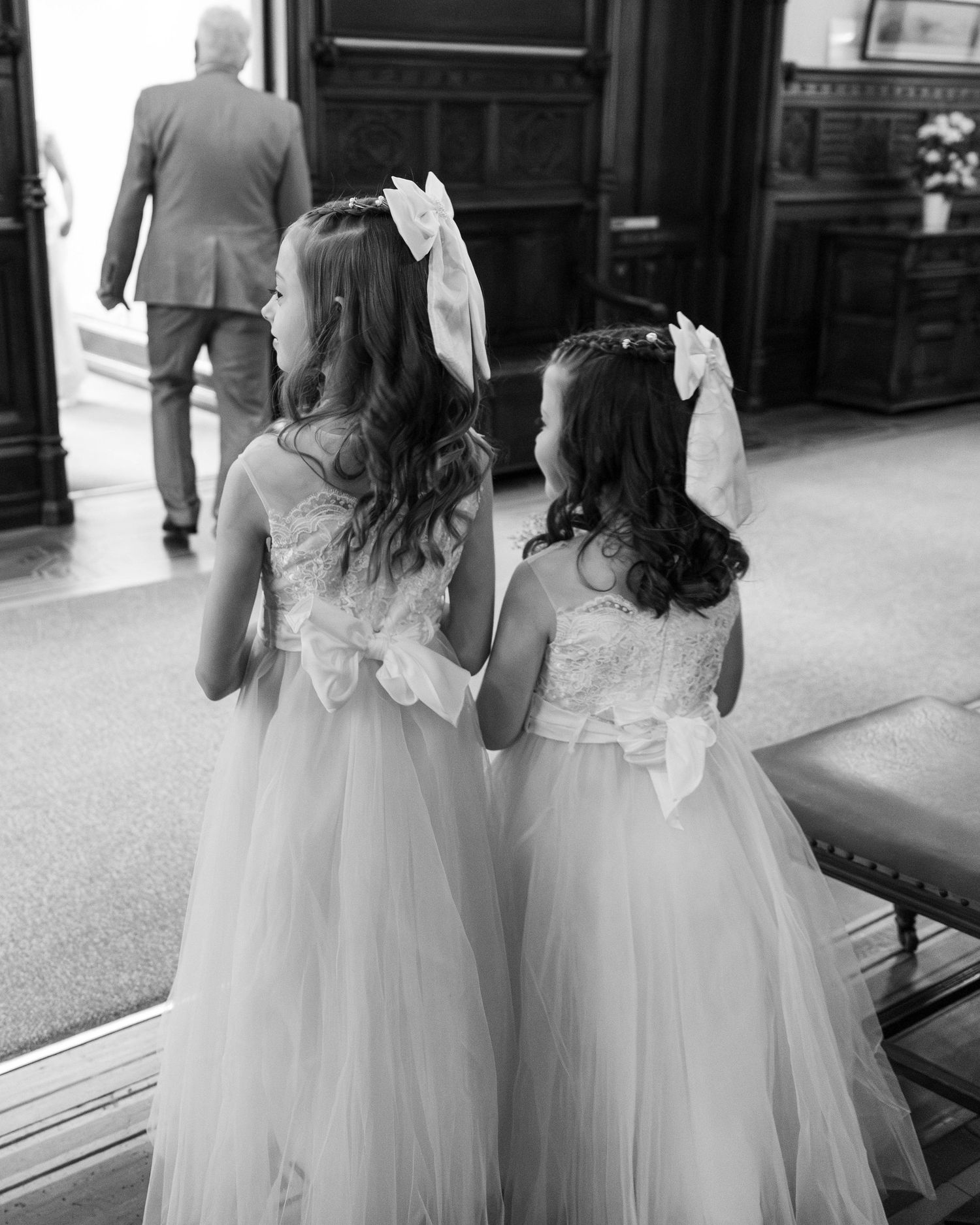 Two bridesmaids walking into the wedding ceremony together, captured by EvieSJPhotography.