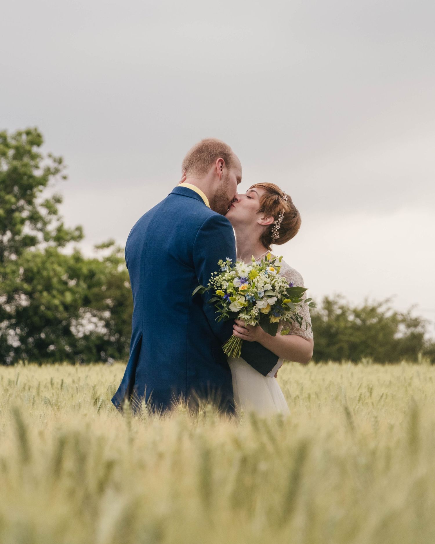 Bride and groom sharing a romantic kiss on their wedding day, captured in a relaxed documentary style by EvieSJPhotography.