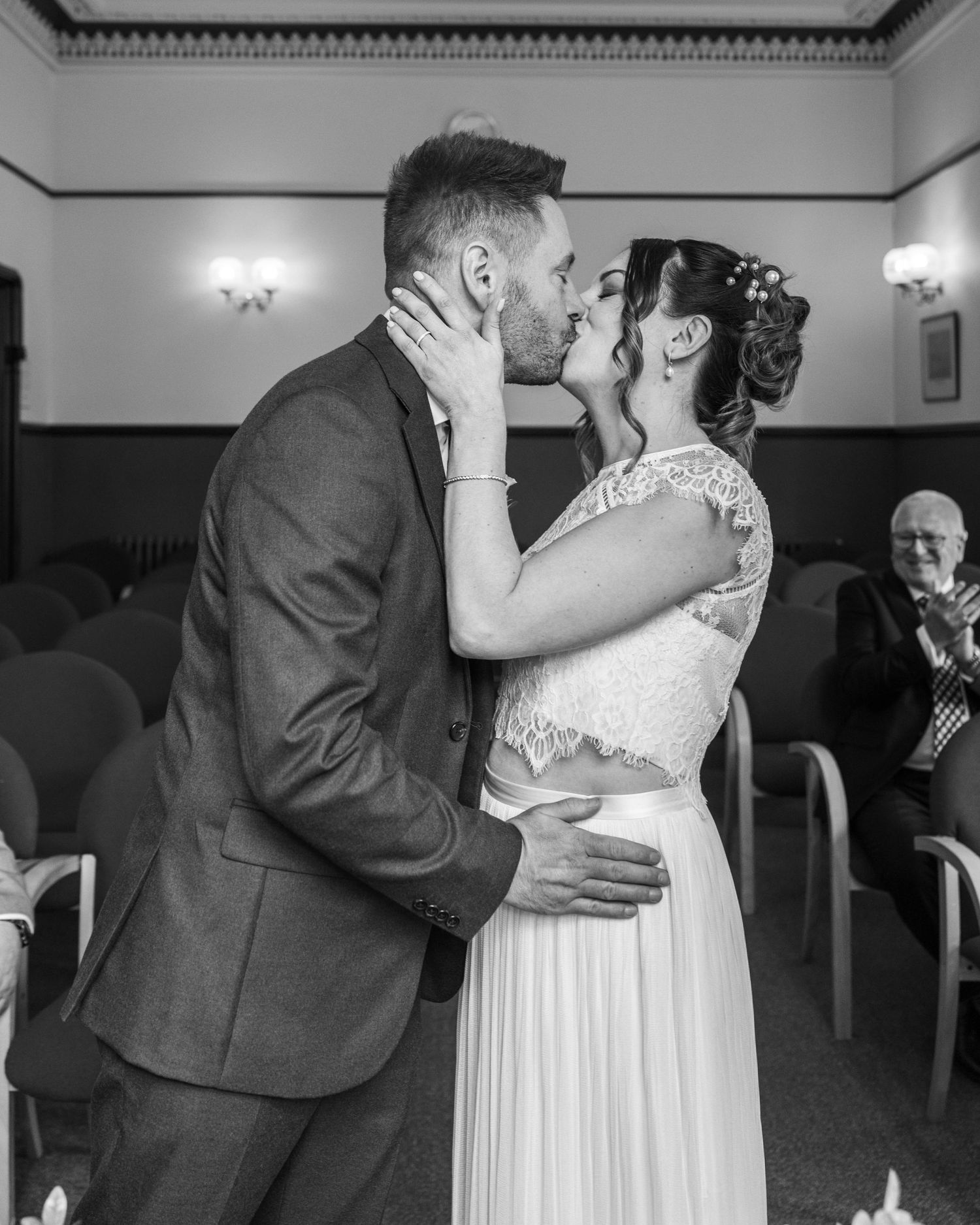 Bride and groom sharing their first kiss on their wedding day, captured in a relaxed documentary style by EvieSJPhotography.